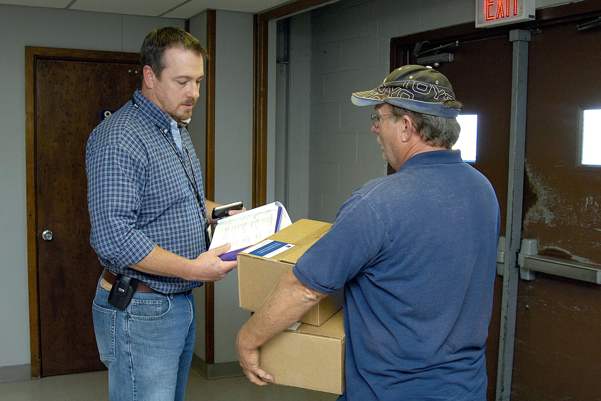 ORI-directed heightened Force Protection Conditions tested Tinker personnel’s response to secure facilities and personnel. At Bldg. 3705, Randy Childress, left, guards an outer door and checks a package being delivered by Carl Whetsel. Mr. Childress is with the 72nd Air Base Wing Communications Directorate. (Air Force photo by Margo Wright)