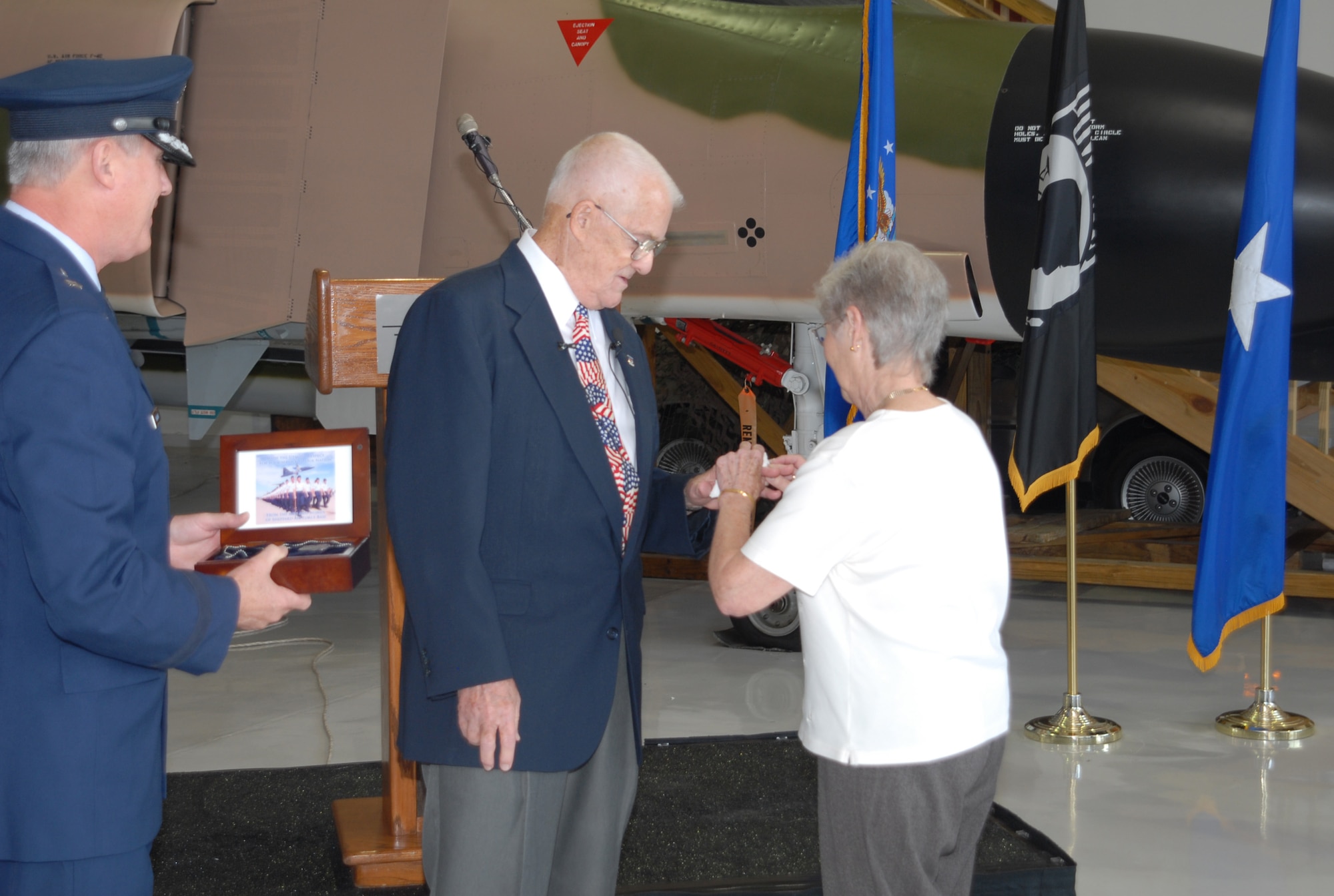 Phyllis Hivner places the original wedding band on the left ring finger of retired Col. James Hivner Nov. 11, 2009, at the Cavanaugh Flight Museum in Addison, Texas. It was the first time the colonel had seen, or worn, the ring since Oct. 5, 1965, when he was shot down and captured in North Vietnam and the ring was taken. The colonel's ring was found recently and eventually passed to retired Navy Cmdr. Rick Tolley who searched for its owner until he found Colonel Hivner.  (U.S. Air Force photo/LouAnne Sledge)