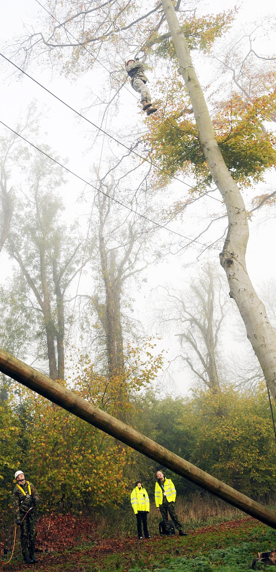 Staff Sgt. Samantha Webb scales a segment of the high-ropes course at Royal Air Force Marham Nov. 9, 2009. She is secured by ropes by a British airman about 50-feet below during the Leadership, Ethos and Air Power Day, a leadership building event hosted by the camp three times a year. About 40 U.S. Airmen from RAFs Mildenhall and Lakenheath were invited to attend the teambuilding activities. Sergeant Webb is from the 48th Security Forces Squadron. (U.S. Air Force photo/Senior Airman Thomas Trower) 