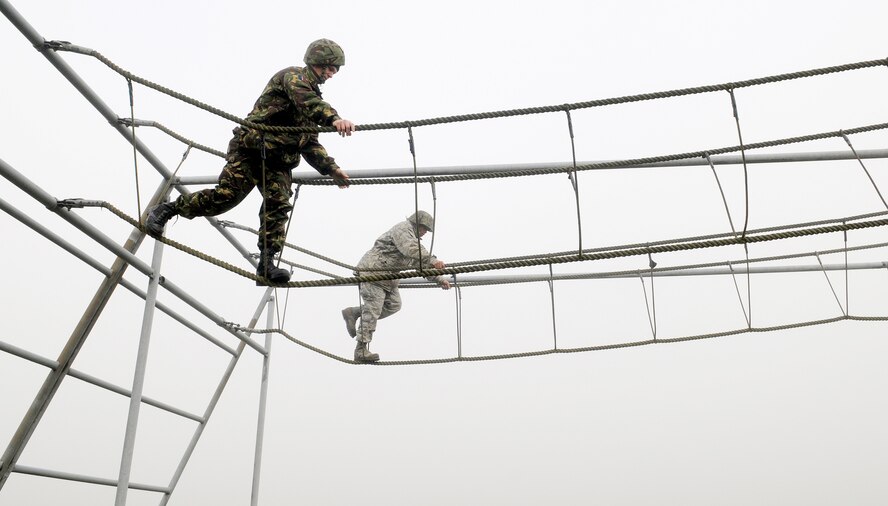 A British airman (left) and 1st Lt. Xzavior Hill, traverse a rope bridge as part of the Ultimate Challenge 2 activity of Leadership, Ethos and Air Power Day at Royal Air Force Marham Nov. 9, 2009. About 40 Airmen from RAFs Mildenhall and Lakenheath participated in the leadership building opportunities with their British counterparts. The event is normally hosted three times a year for RAF troops. The overall goal is to foster teambuilding and teach effective leadership techniques. Lieutenant Hill is from the 100th Civil Engineer Squadron. (U.S. Air Force photo/Senior Airman Thomas Trower)
