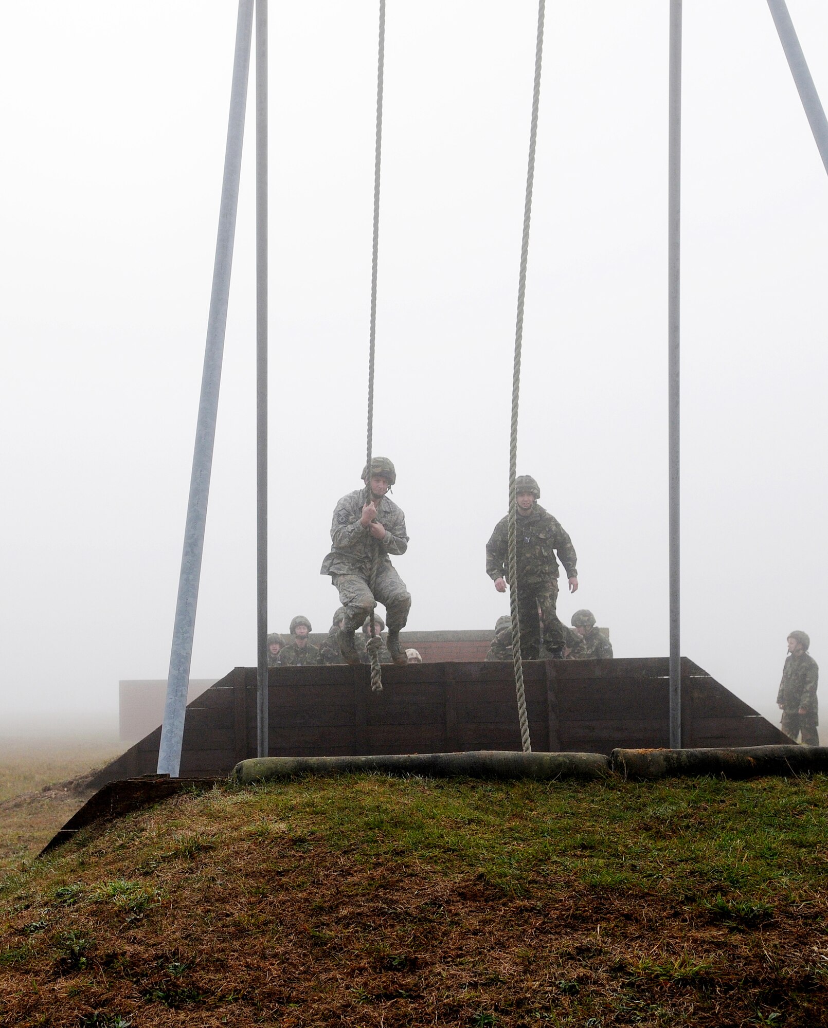 Master Sgt. Matthew Poole (left) swings over a sand pit during Leadership, Ethos and Air Power Day at Royal Air Force Marham Nov. 9, 2009. About 40 Airmen from RAFs Mildenhall and Lakenheath participated in the leadership building opportunities with their British counterparts. The event is normally hosted three times a year for RAF troops. The overall goal is to foster teambuilding and teach effective leadership techniques. Sergeant Poole is from the 48th Munitions Squadron. (U.S. Air Force photo/Senior Airman Thomas Trower) 