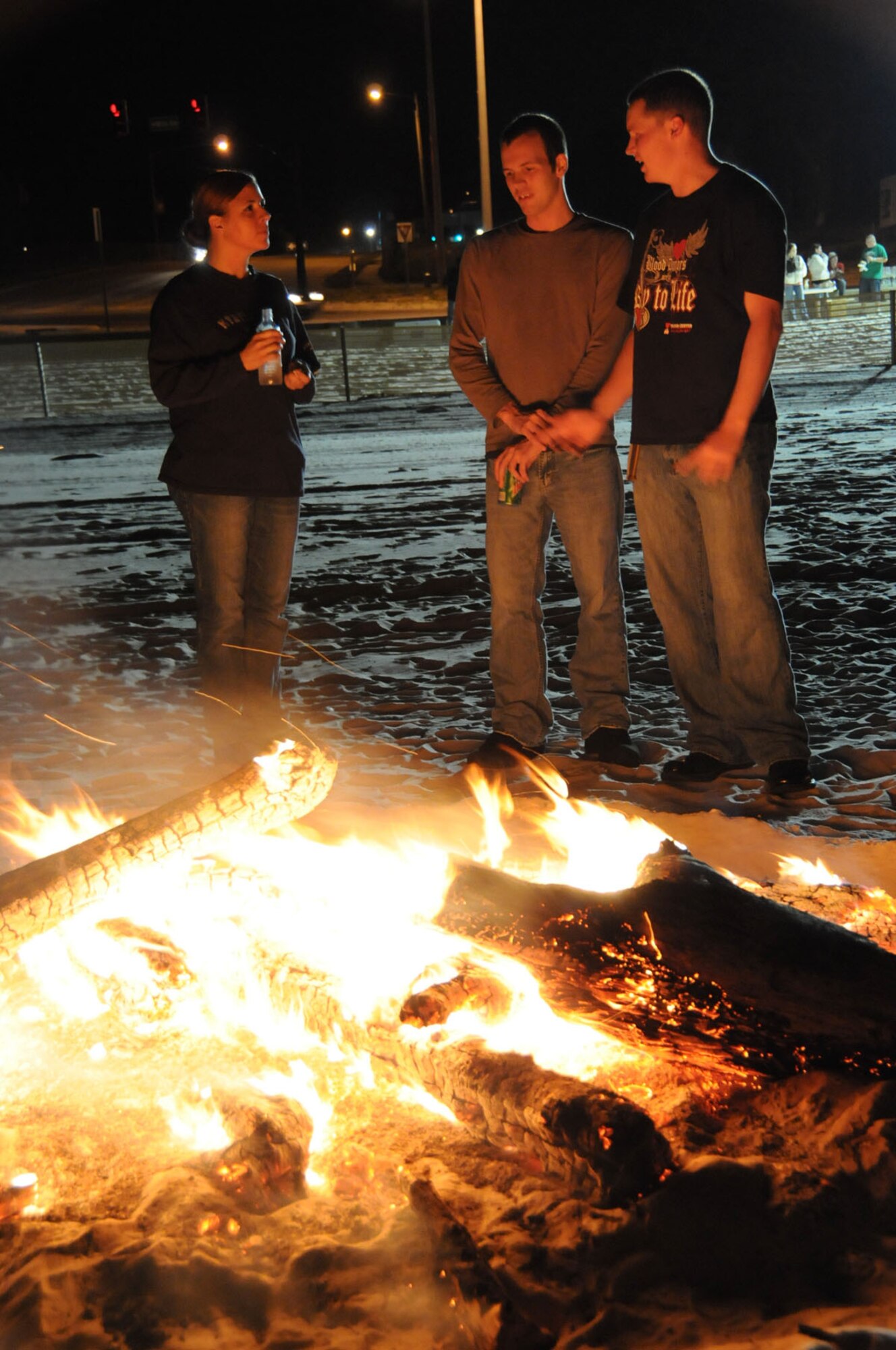 From left, Master Sgt. Crystal Mathes and Airman Mathew Kortuem, 81st Medical Support Squadron, and Senior Airman Marthinus Taljaard, 81st Diagnostics and Therapeutics Squadron, chat at a bonfire on the beach in Biloxi Friday.  The event was for permanent-party single members.   (U.S. Air Force photo by Kemberly Groue)