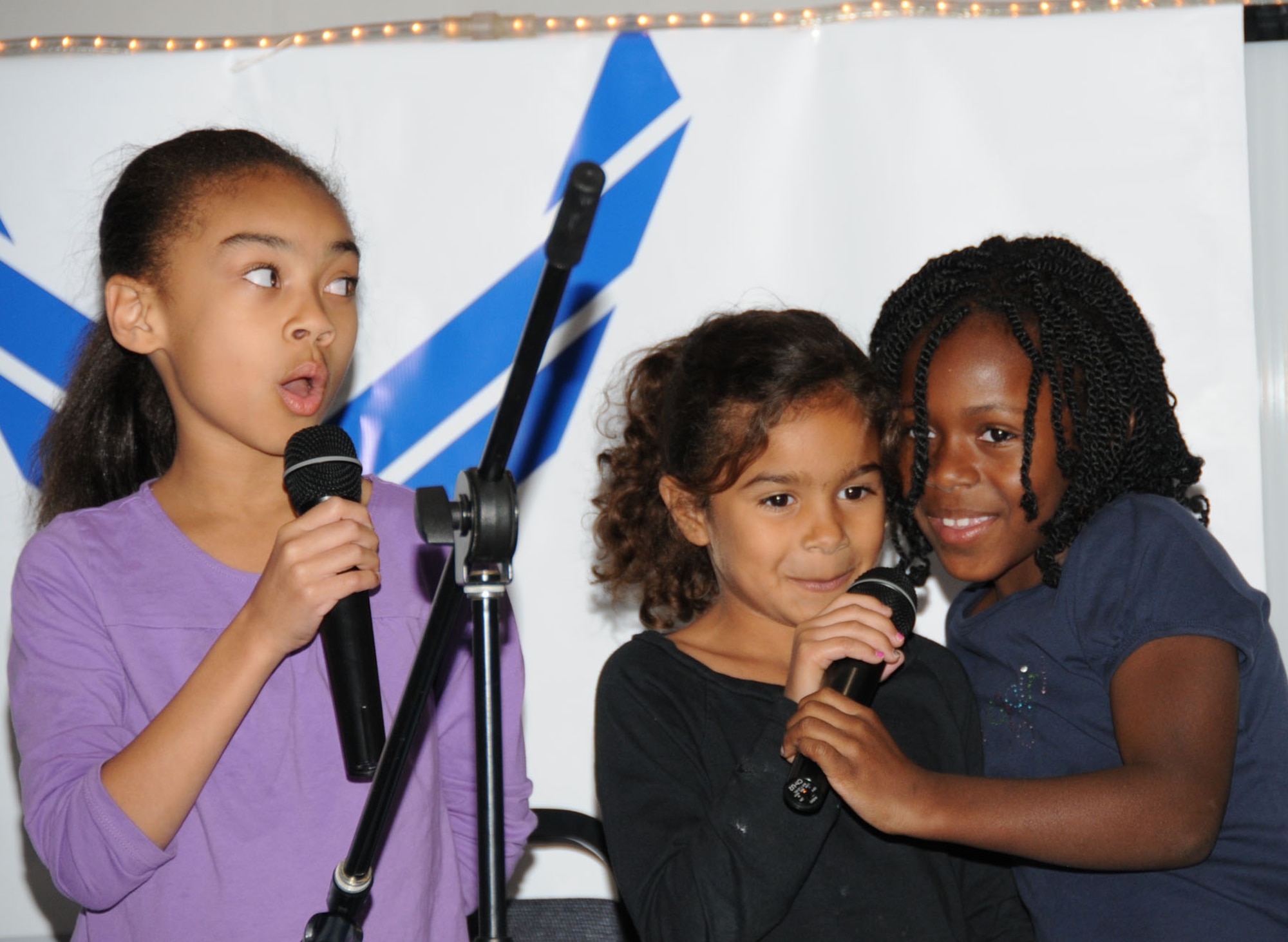 From left, Taylor Bills, 7; Jordyn Simmons, 6, and Samira Liggett, 7, sing at Friday’s talent show at the youth center.  Taylor’s parents are Jacqulyn and James Bills, CSC.  Jordyn’s parents are Chief Petty Officers Michelle Deshotel, Keesler Center for Naval Aviation Technical Training Unit, and Chris Simmons, Fleet Area Control and Surveillance Facility, Jacksonville, Fla.  Samira is the daughter of Senior Airman Jazmin and Carlin Butler, 81st Logistics Readiness Squadron.   (U.S. Air Force photo by Kemberly Groue)