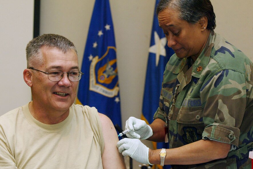 Maj. Zenabo Witherspoon, 94th Aeromedical Evacuation Squadron, administers a flu injection to Lt. Col. William B. Ferrell, 94th Airlift Wing Base Chaplain, during a base wide flu vaccination program held at 22nd Air Force headquarters building Nov. 7 (U.S. Air Force photo/Don Peek)