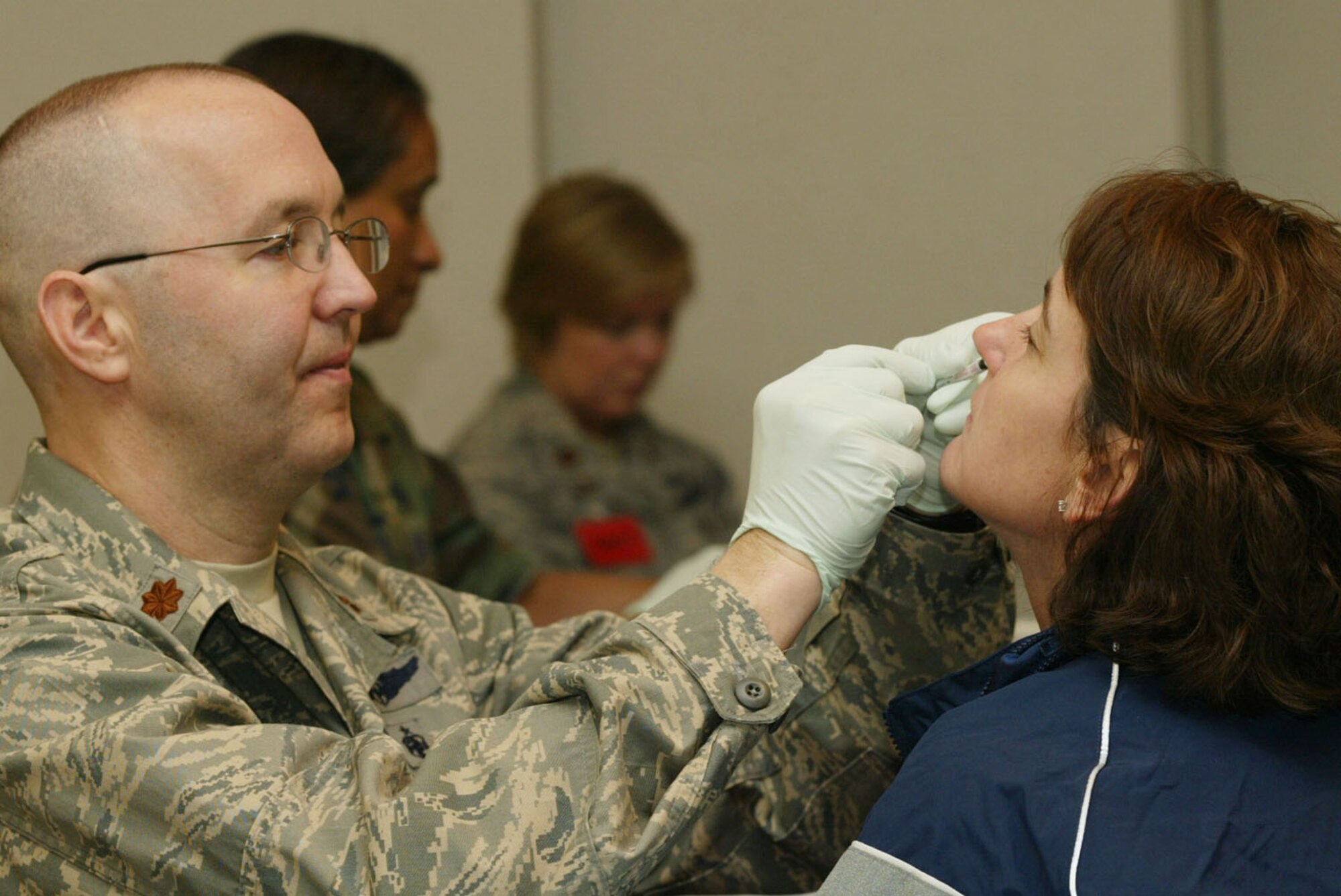 Maj. James Martin, a flight nurse from the 94th Aeromedical Staging Squadron, gives a flu vaccine nasal mist to Senior Master Sgt. Alexandra Meyer, a member of the 622nd Regional Support Group, during a base wide flu vaccination program held at the 22nd Air Force headquarters building Nov. 7. (U.S. Air Force photo/Don Peek)