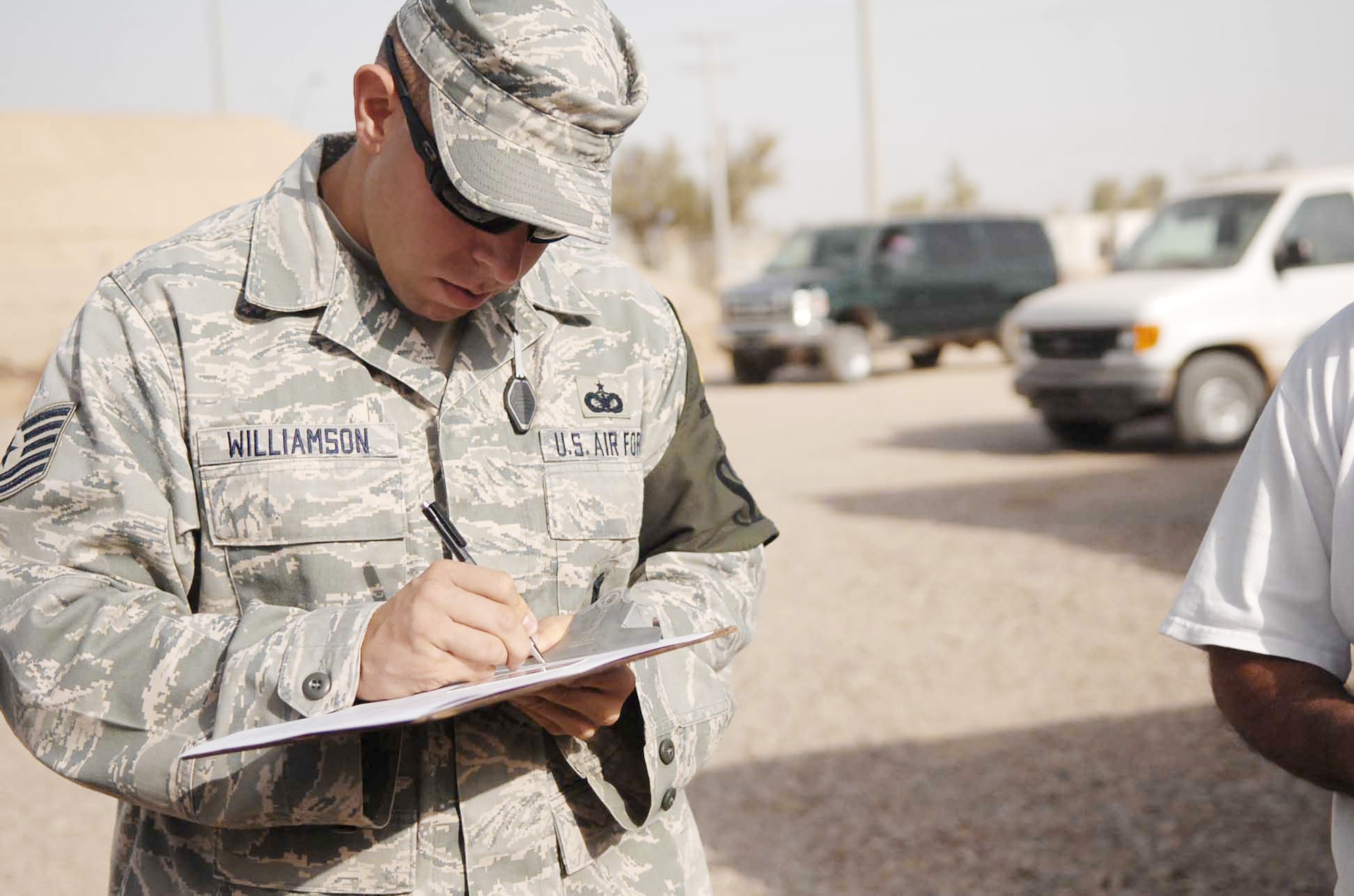 Tech. Sgt. Thomas Williamson notates names of third-country nationals undergoing random antiterrorism measures on base Nov. 6, 2009, at Joint Base Balad, Iraq. The procedures aim to eliminate predictability in the installation's force-protection plan. Sergeant Williamson is the 332nd Expeditionary Security Forces Squadron NCO in charge of operations support. (U.S. Air Force photo/Senior Airman Andria J. Allmond)
