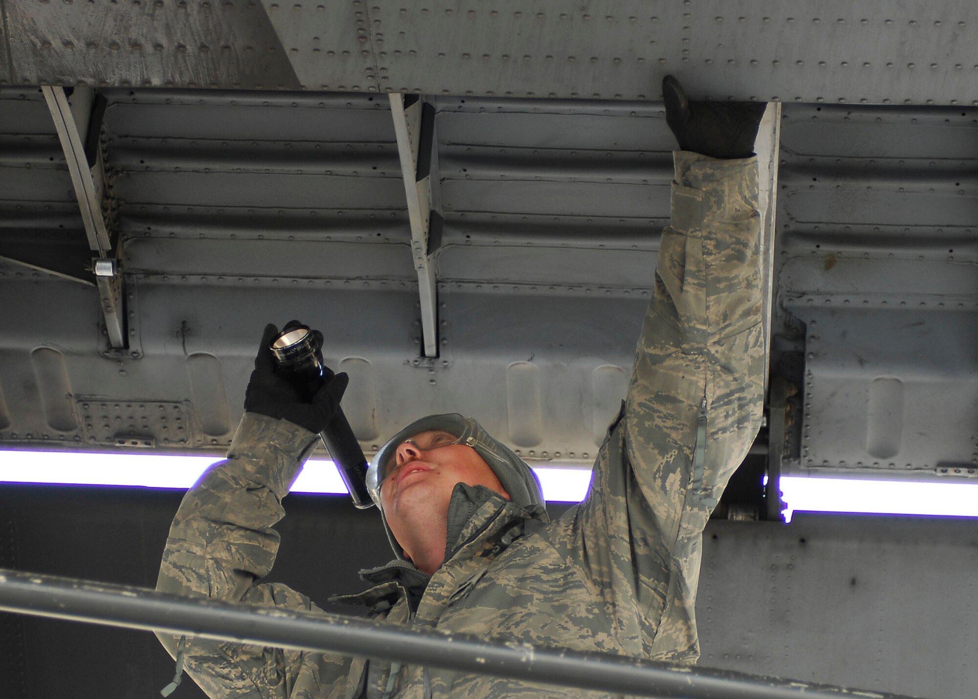 BAGRAM AIRFIELD, Afghanistan -- Senior Airman Stephen Waters, a crew chief from the 41st Expeditionary Electronic Combat Squadron, performs an inspection on the EC-130 Compass Call Nov. 12, 2009.  The Compass Call system employs offensive capabilities in support of U.S. and Coalition tactical air, surface, and special operations forces.  Airman Waters, a Port St. Lucie, Fla. native, is deployed from Davis-Monthan Air Force Base, Ariz.  (U.S. Air Force photo/Senior Airman Felicia Juenke)