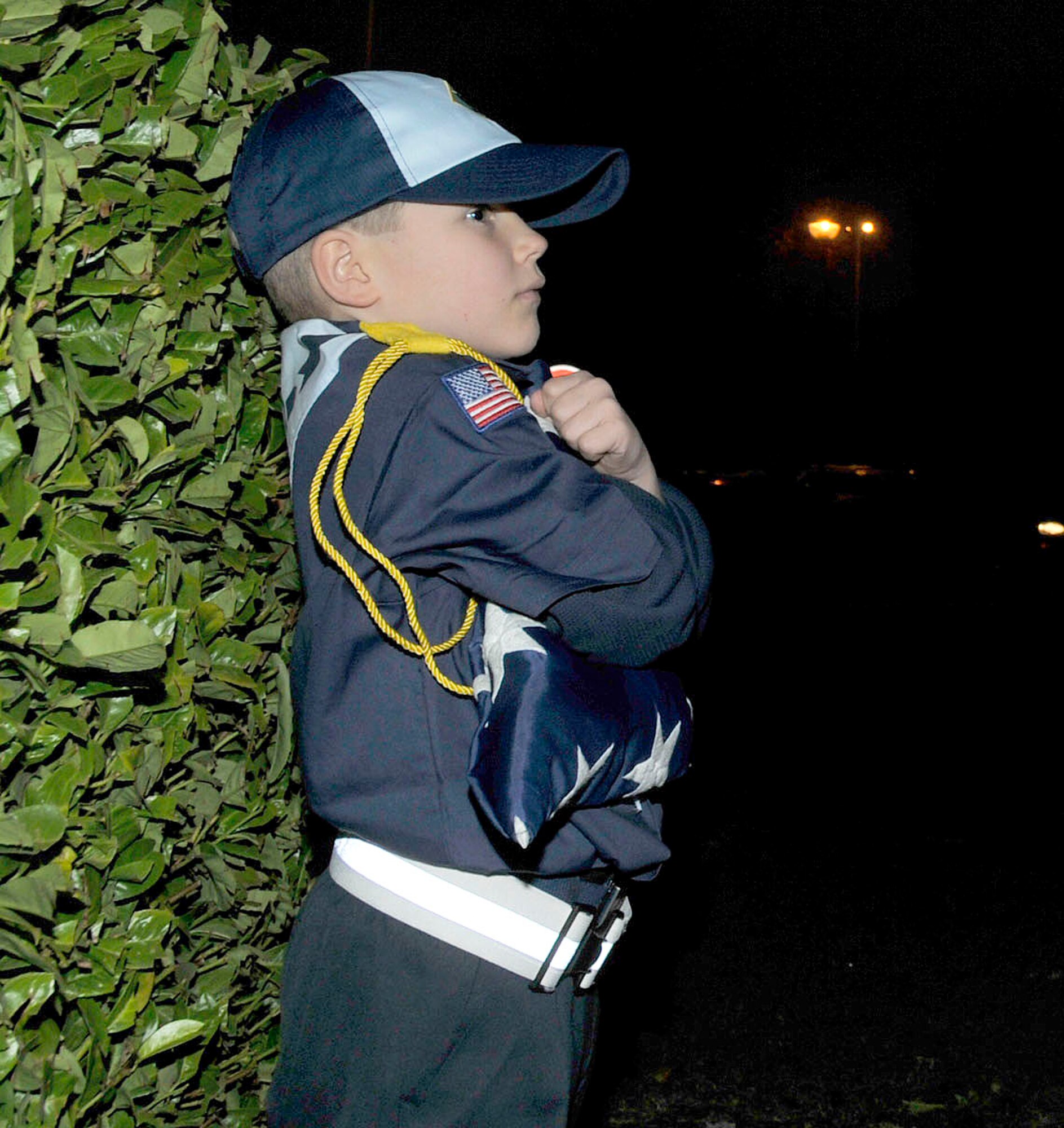 Matthew Vaughn, cub scout, son of Tech. Sgt. Caroline Vaughn, 48th Communications Squadron unit deployment manager, and Master Sgt. William Vaughn, 100th Civil Engineer Squadron superintendent, holds the American flag after the flag is properly folded during a retreat ceremony at RAF Lakenheath, England Nov. 9. The Cub Scouts assisted with the ceremony and received hands-on experience as part of their community service project.  (U.S. Air Force photo/Airman 1st Class Eboni Knox)