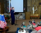 HARVEY, N.D. -- Airman 1st Class Aaron Storer, 5th Aircraft Maintenance Squadron hydraulics apprentice, delivers a speech to elementary school students and their families at a local church here Nov.11. Airman Storer’s contribution to the community is a continuing example of the strong relations shared throughout Team Minot. (U.S. Air Force photo by Senior Airman Michael Veloz)