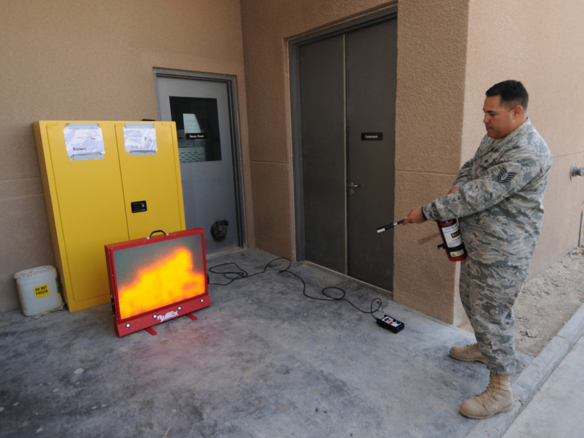 Tech. Sgt. John Serrato, 379th Expeditionary Civil Engineer Squadron lead fire inspector, demonstrates proper fire extinguisher use and safety using the BullEx Digital Safety fire training simulator at a deployed location in Southwest Asia, Nov. 9, 2009. Sergeant Serrato is deployed from Minot Air Force Base, N.D. in support of operations Iraqi Freedom and Enduring Freedom. (U.S. Air Force Photo/Tech. Sgt. Jason W. Edwards)