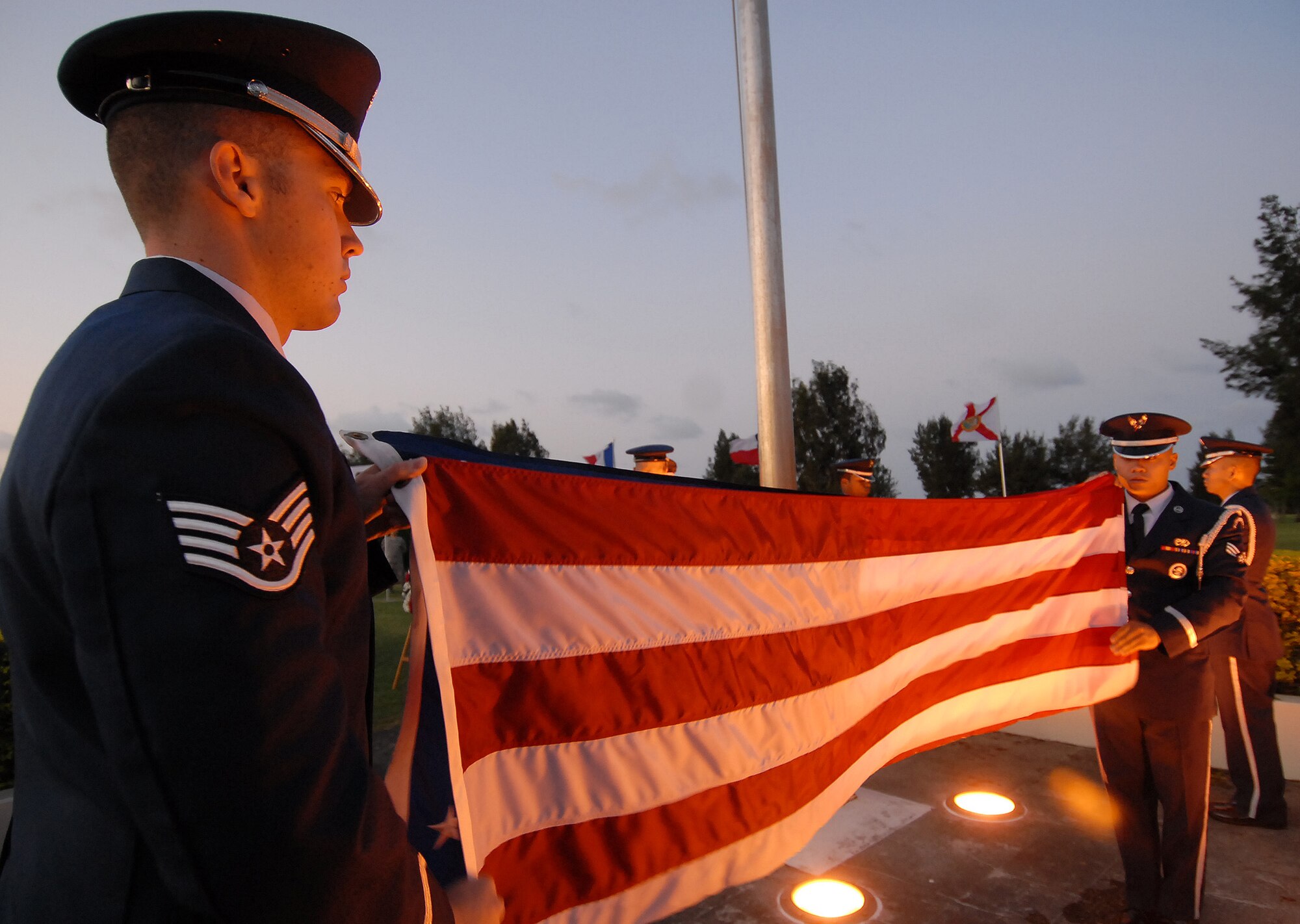 Kadena Honor Guardsmen Staff Sgt. Kristofer Talbott, 18th Civil Engineer Squadron, and Senior Airman Marc Pillarda, 18th Communications Squadron, fold the American flag shortly before the start of a Veteran's Day ceremony held at 18th Wing Headquarters Nov. 11. Approximately 200 servicemembers, friends and families attended the event as well as retired veterans from the local American Legion and Veterans of Foreign Wars units. Petty Officer Third Class Harry Thomas, a retired Navy corpsmen from World War II, spoke about the importance of military service to the nation and reassured servicemembers that retired veterans "will always watch your back." (Air Force/Staff Sgt. Jason Lake)