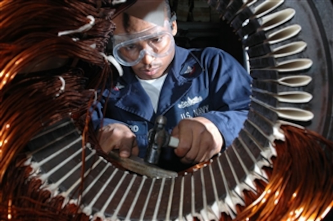 U.S. Navy Petty Officer 3rd Class Tyreek Hayward lays coil to rewind a motor in the machine shop aboard the aircraft carrier USS Nimitz (CVN 68) while underway in the Persian Gulf on Nov. 9, 2009.  The Nimitz is on deployment to the U.S. 5th Fleet area of operations.  