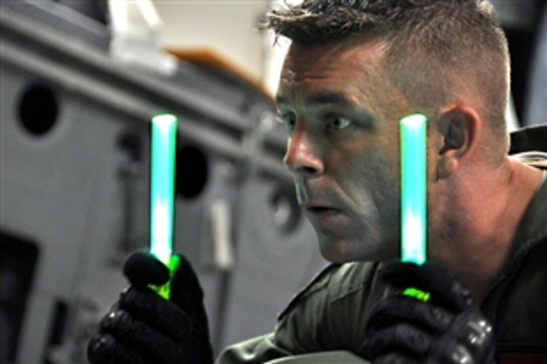 U.S. Air Force Tech Sgt. Kevin Collette guides a K-loader into a C-17 Globemaster III cargo aircraft on Hickam Air Force Base, Hawaii, Nov. 7, 2009. Collette and the rest of his crew are transporting dolphins from the U.S. Navy Marine Mammals Program to Noumea, New Caledonia, where they will participate in a humanitarian project in which U.S. Navy, French, Australian and New Zealand demolition crews will remove mines left over from World War II.