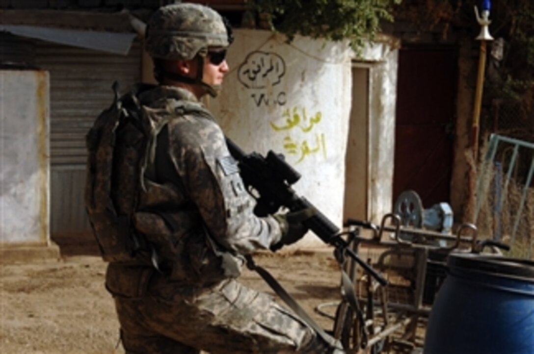 U.S. Army 1st Lt. Andrew Bryant, platoon leader for White Platoon, Alpha Battery, 1-77 Field Artillery Battalion, provides security while members of the Wasit Provincial Reconstruction Team survey a site for an upcoming arts festival in Kut, Iraq, on Nov. 6, 2009.  The Provincial Reconstruction Team is sponsoring the arts festival to help increase the visibility of local artists and to improve commerce.  