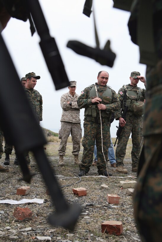 Georgian Army Senior Lt. Gorgodze Zaza, Alpha company commander, 31st Light Infantry Battalion, gathers his men in a company school circle and issues his mission's orders. Zaza built a makeshift sand table on the ground using rocks, sticks and whatever else he could find to represent the terrain features. The Georgia Deployment Program is a two-year training program with a goal to increase interoperability between the Georgian Army and International Security Assistance Forces (ISAF). The training consists of four 6-month rotations designed to train four Georgian infantry battalions in counterinsurgency tactics, techniques and procedures in preparation for their deployment to Afghanistan in support of ISAF. (U.S. Marine Corps photo by Master Sgt. Grady T. Fontana)