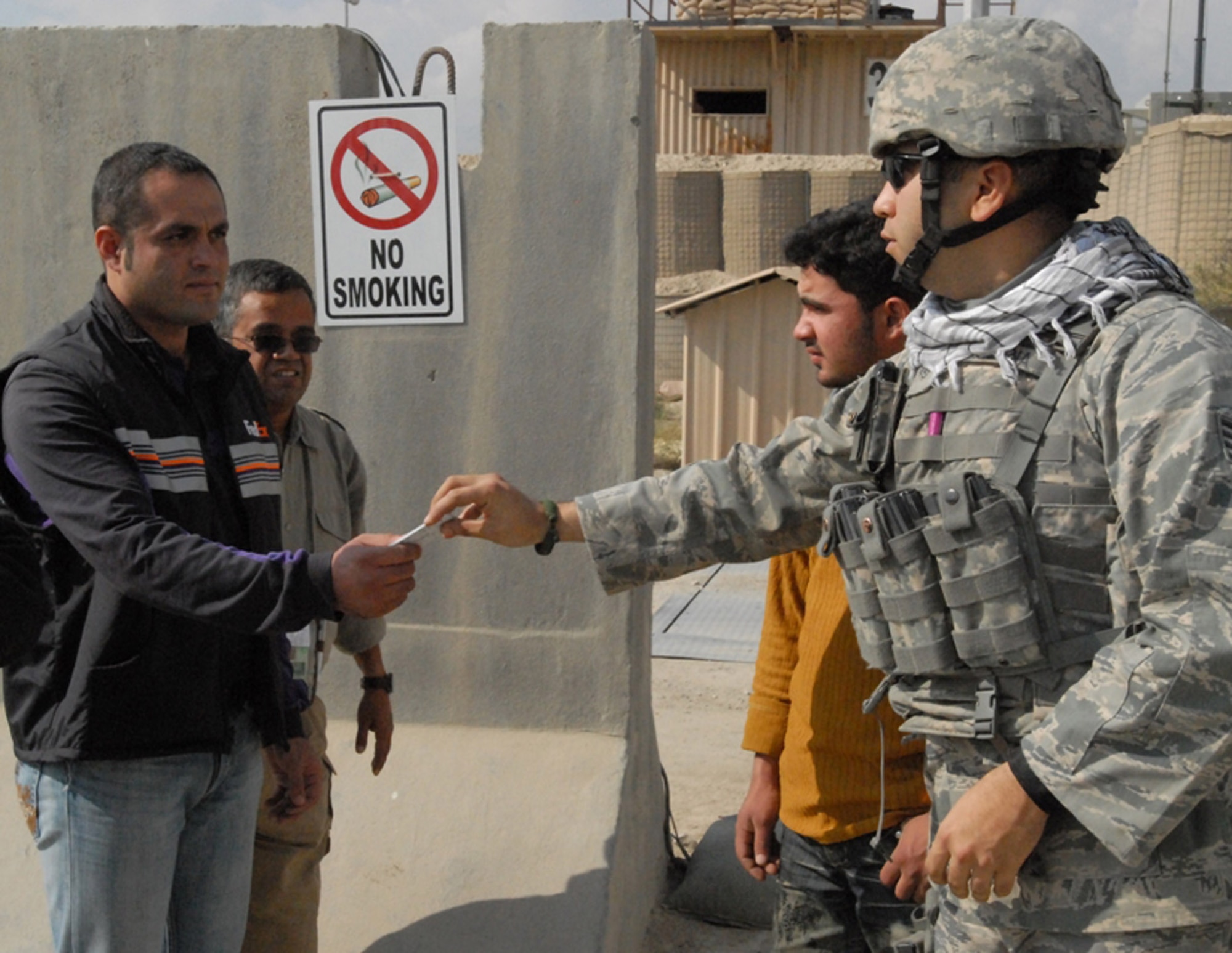 BAGRAM AIRFIELD, Afghanistan -- Staff Sgt. Alex Medina, a 455th Security Forces Squadron Airman, checks the identification of local workers entering the airfield. Sergeant Medina, a Miami native, is deployed from the 52nd Security Forces Squadron based at Spangdahlem Air Base, Germany. (U.S. Army photo/Spc. William E. Henry)