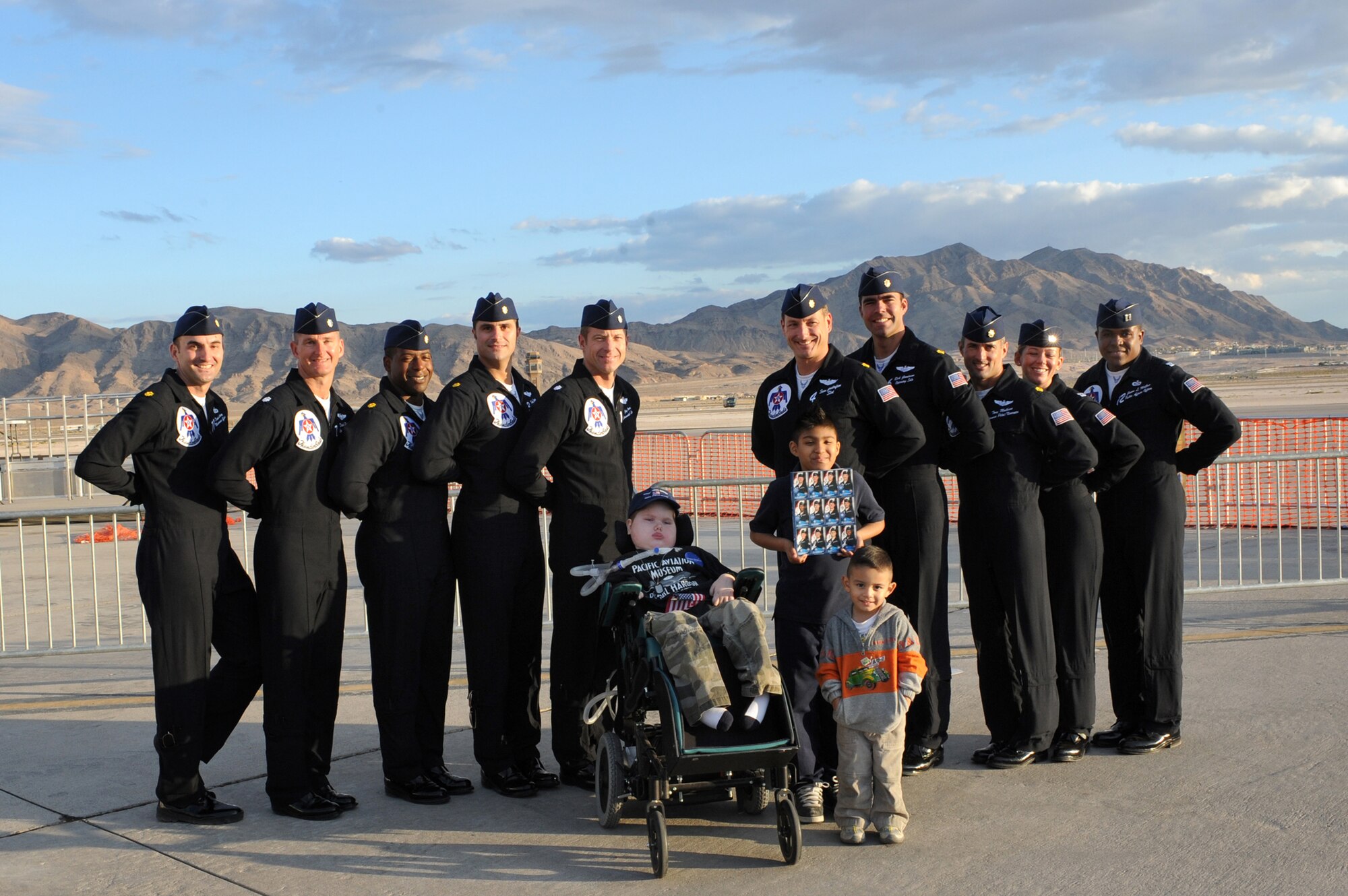 NELLIS AIR FORCE BASE, Nev.-- The U.S. Air Force Demonstration Team Thunderbirds pose for a photo with Matt Dembik Jr. and Angel Sotelo, make a wish recipients, after the conclusion of the rehearsal day for the Nellis Open House Nov. 13. The Make a Wish Foundation is a non-profit organization aimed toward granting wishes of children with life-threatening conditions. (U.S. Air Force photo by Tech. Sgt. Michael R. Holzworth)