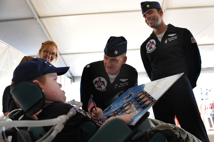 NELLIS AIR FORCE BASE, Nev.--  Matt Dembik Jr., a nine year-old diagnosed with spinal muscular atrophy gets his picture autographed by Maj. Rick Goodman, U.S. Air Force Aerial Demonstration Team Thunderbirds solo pilot, and Lt. Col. Derek Routt Thunderbirds operations officer during the rehearsal show for the Nellis Open House Nov. 13. Matt was invited to attend the rehearsal day through the Make a Wish Foundation. The Make a Wish Foundation is a non-profit organization aimed toward granting wishes of children with life-threatening conditions.(U.S. Air Force photo by Tech. Sgt. Michael R. Holzworth)