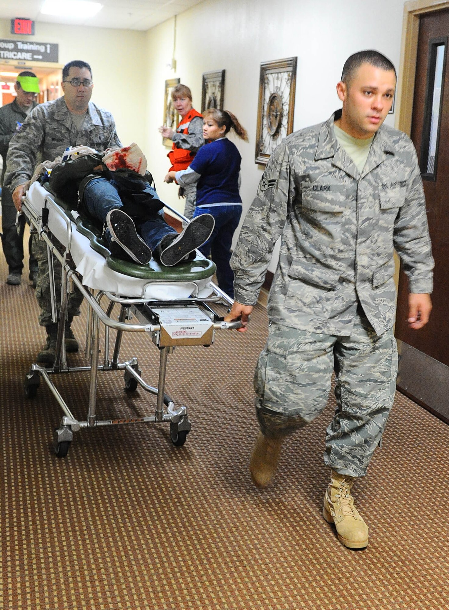 DYESS AIR FORCE BASE, Texas -- Airman 1st Class Jordan Clark, 7th Medical Operations Squadron, leads the gurney carrying an injured patient to an alternate location for care during a mass casualty training exercise here Nov. 13. All 7th Medical Group personnel participated in the mass casualty exercise which called for immediate response and emergency care to the volunteer moulage victims.  (U.S. Air Force photo by Senior Airman Domonique Washington)

