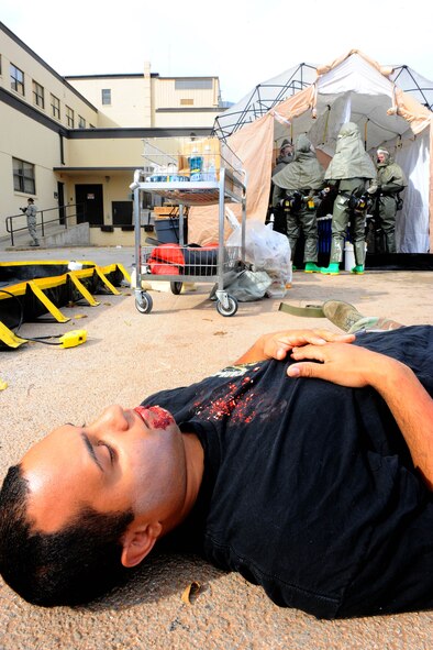 DYESS AIR FORCE BASE, Texas -- Staff Sgt. Danel Mendoza, 7th Maintenance Operations Squadron, lies on the ground covered in bodily fluids as he waits to be decontaminated during a mass casualty training exercise here Nov. 13. The 7th Medical Group conducted this exercise consisting of 25 moulage victim volunteers and the entire medical group staff.  (U.S. Air Force photo by Senior Airman Domonique Washington)