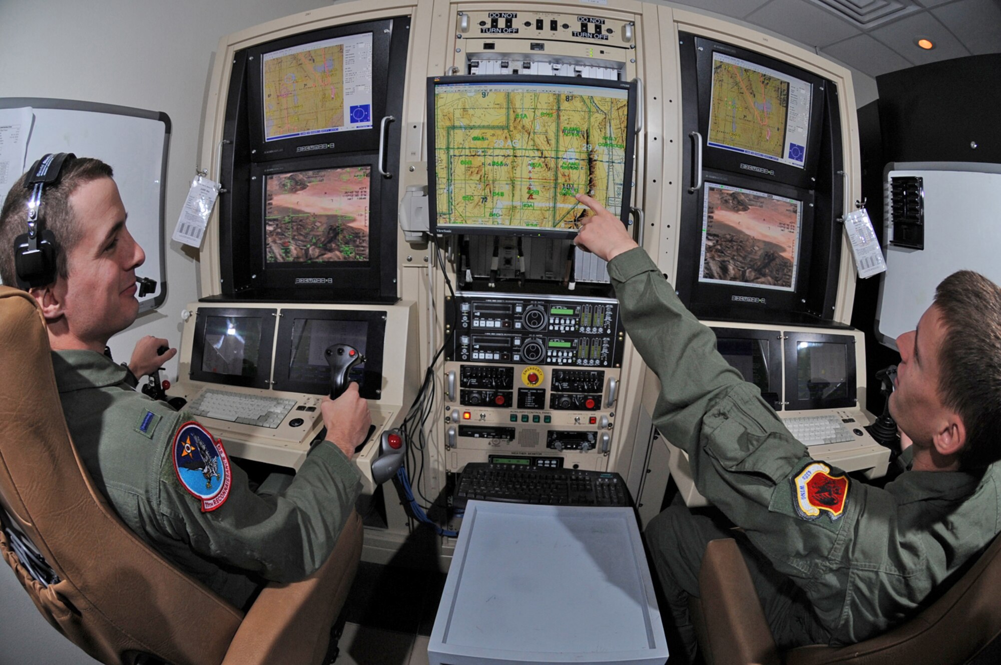 Airman 1st Class Caleb Force assists 1st Lt. Jorden Smith, a MQ-1B Predator pilot, in locating simulated targets during a training mission conducted inside the simulators at Creech Air Force Base, Nev. Airman Force is a MQ-1B Predator sensor operator. Both are assigned to the 11th Reconnaissance Squadron. (U.S. Air Force photo/Senior Airman Nadine Y. Barclay)