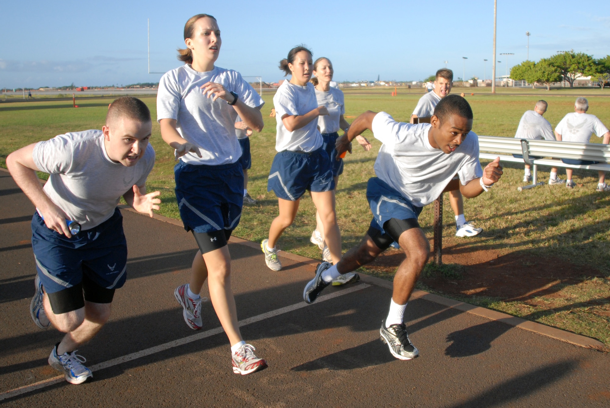 Members of 13th Air Force pass batons while competing in a relay race during Jungle Day Nov. 13 at Hickam Air Force Base, Hawaii. The Jungle Day tradition originated when the organization was assigned to Andersen Air Force Base, Guam, and gives 13th Air Force members a chance to have fun and give back to the local community. (U.S. Air Force photo/Senior Airman Gustavo Gonzalez)