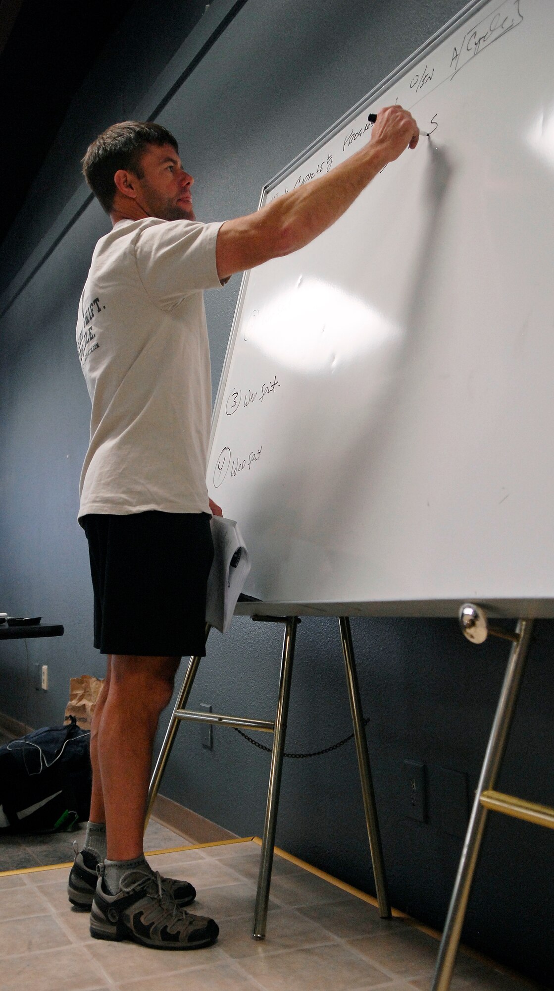 Rob Shaul, strength and conditioning coach, writes notes on the board during a fitness class held at Luke AFB, Nov. 3. According to Criticalbench.com, Mr. Shaul is a Certified Strength and Conditioning Coach through the National Strength and Conditioning Association, and has attended seminars/certifications through CrossFit, Gym Jones, U.S. Weightlifting, and Athletes’ Performance.  He founded Military Athlete in January, 2009. He is also a 1990 graduate of the US Coast Guard Academy.  (U.S. Air Force photo by Airman 1st Class Ronifel Yasay)