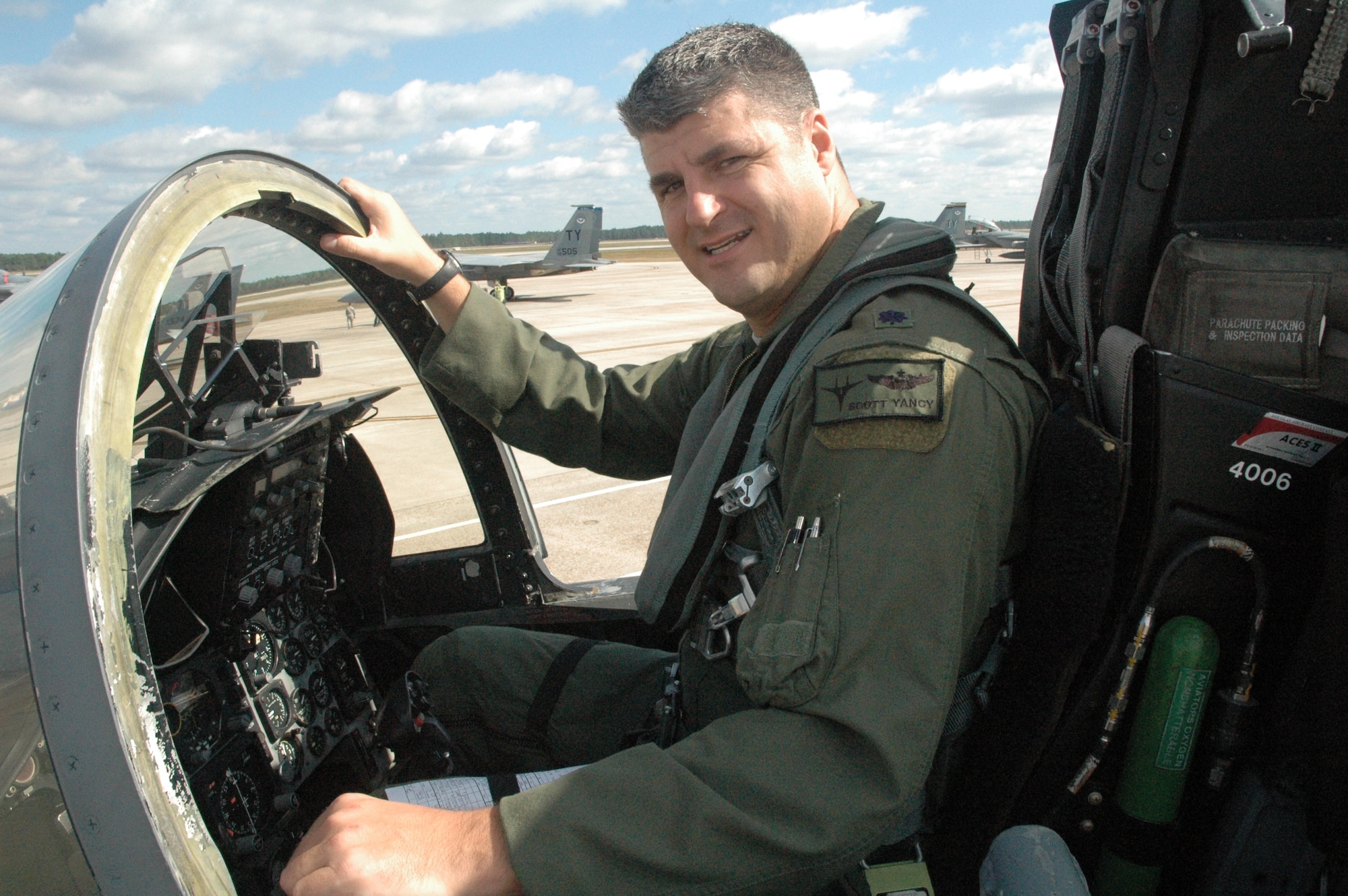 Lieutenant Colonel Scott Yancy, 95th Fighter Squadron Commander poses in his part-time office-the cockpit of an F-15C. (U.S. Air Force photo by Major Veronica Kemeny)