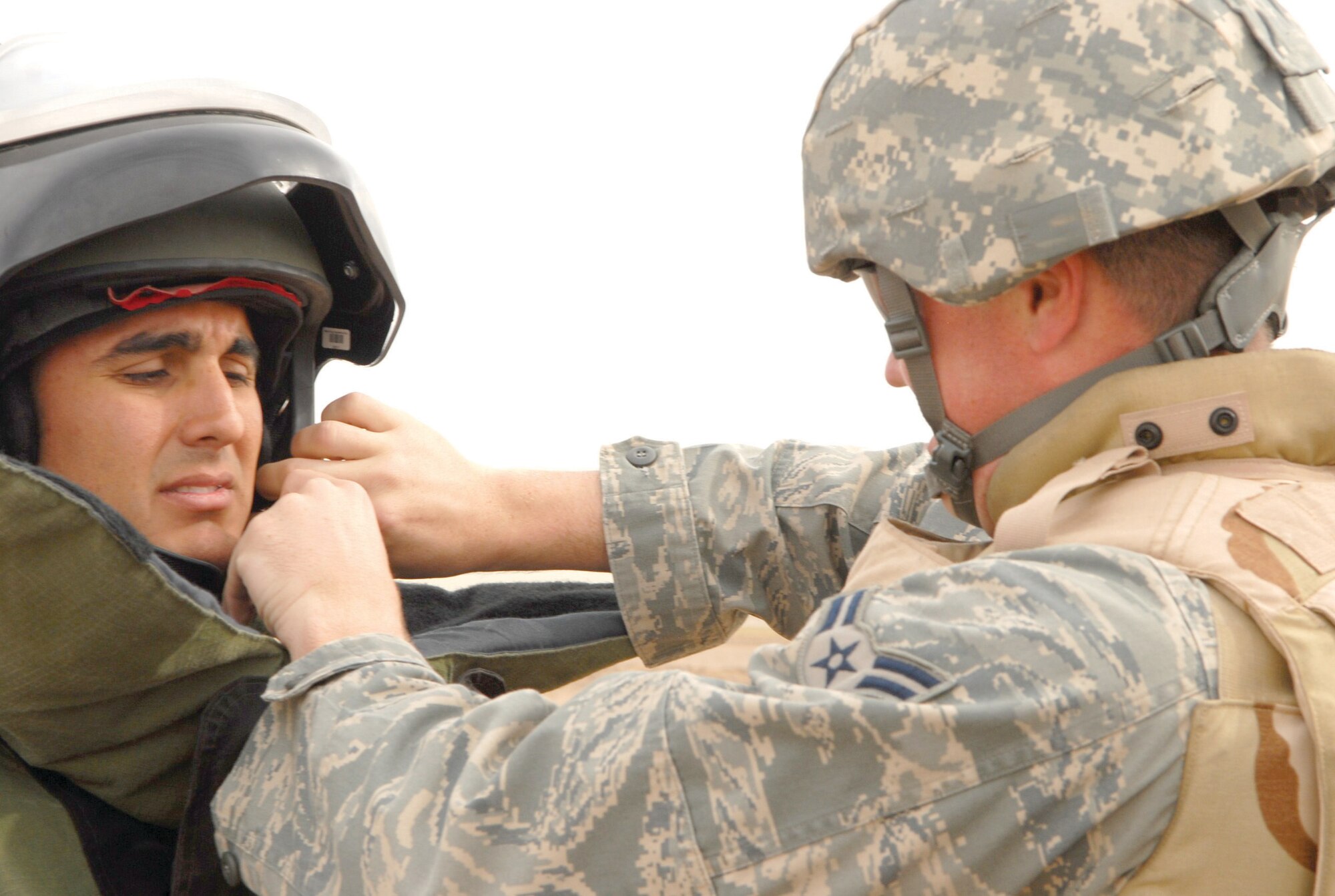 Airman 1st Class Benjamin George (right) helps adjust an Explosive Ordinance Disposal 9 bomb suit helmet strap for Staff Sgt. Joe Hernandez, 56th Civil Engineer Squadron technicians at the EOD proficiency range, Nov. 6. (U.S. Air Force photo by Senior Airman Tong Duong)