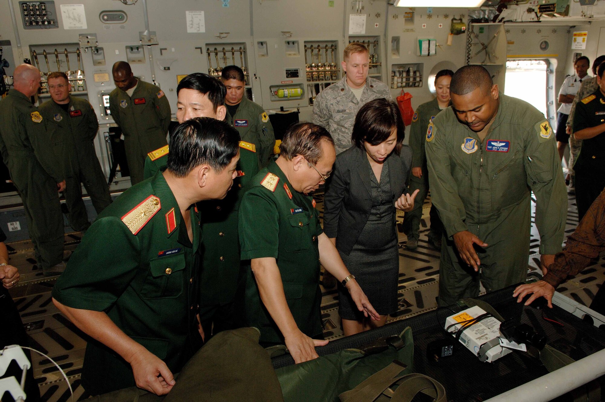 Tech. Sgt. John Stevens, non-commissioned officer in charge of aircrew scheduling in the 18th Aerospace Medicine Squadron at Kadena Air Base, Japan, talks with Vietnam military delegates during a tour of a C-17 Globemaster III at Hickam Air Force Base, Hawaii, Nov. 10.  Six delegates from the Vietnam military health and general logistics fields met with U.S. Air Force officials at Hickam during a 13th Air Force-hosted visit.   The delegates learned how the U.S. military conducts surveillance, screening and testing of infectious diseases, and how the U.S. Air Force plans and conducts logistics operations. (U.S. Air Force photo/Mark Bates)