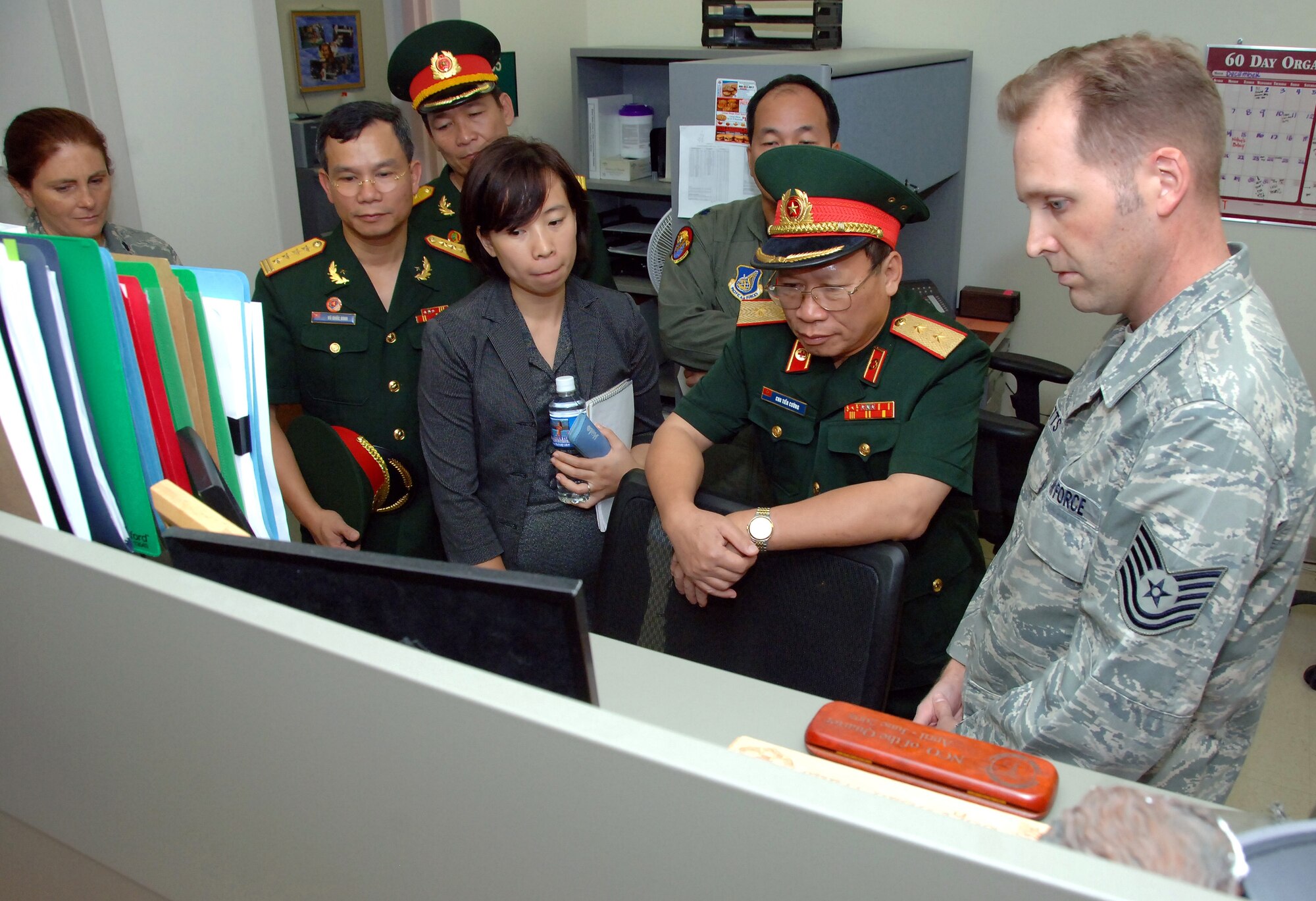 Tech. Sgt. Brian Watts, a public health craftsman in the 15th Aeromedical-Dental Squadron, explains to Lt. Gen. Chu, Tien Cuong, director of the Vietnam Military Medical Department, how the U.S. Air Force uses a database to track individual medical readiness during the general’s visit to Hickam Air Force Base, Hawaii, Nov. 10. Six delegates from the Vietnam military health and general logistics fields met with U.S. Air Force officials at Hickam during a 13th Air Force-hosted visit.   The delegates learned how the U.S. military conducts surveillance, screening and testing of infectious diseases, and how the U.S. Air Force plans and conducts logistics operations. (U.S. Air Force photo/Vanessa Forloine)