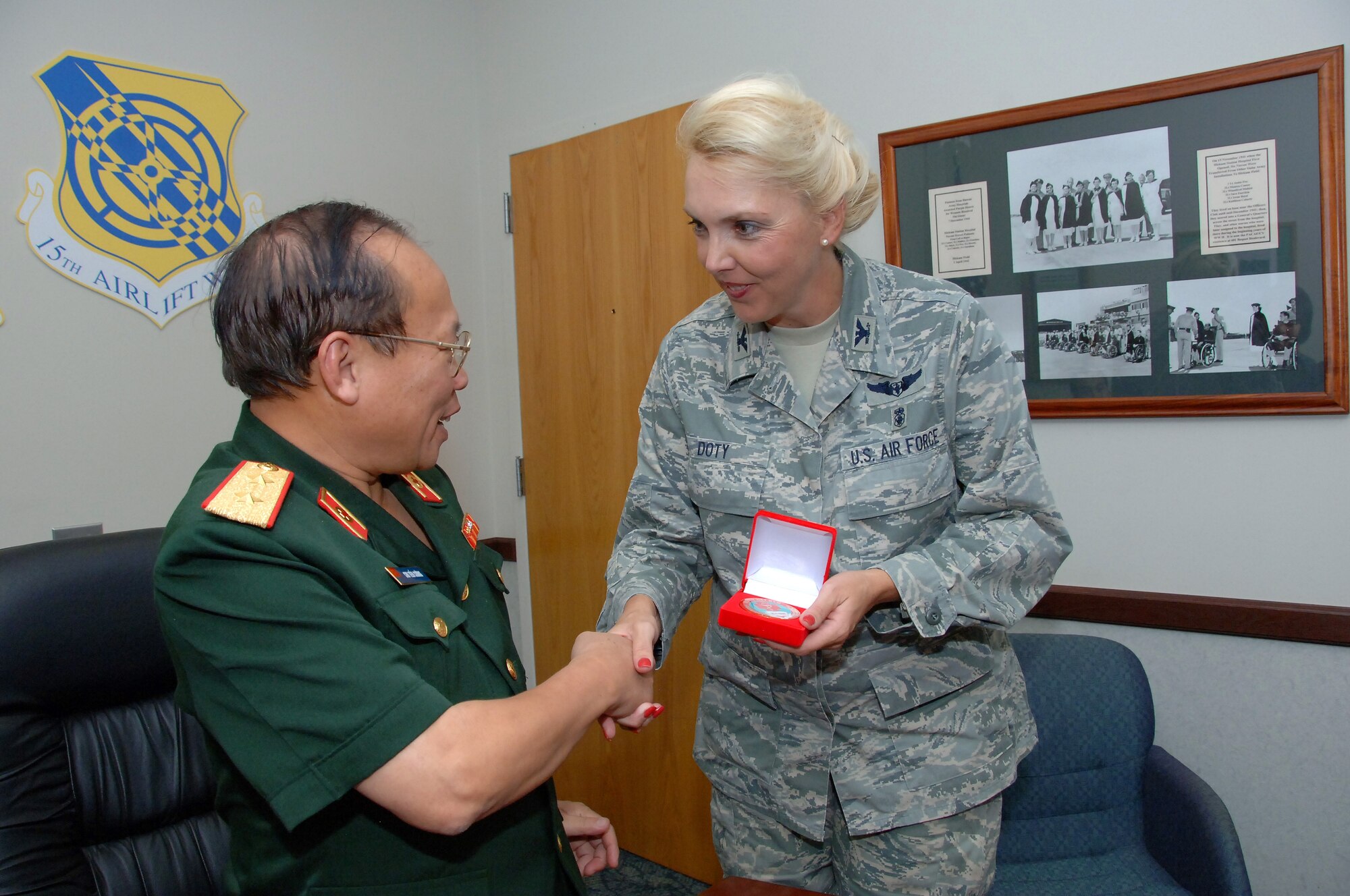 Lt. Gen. Chu, Tien Cuong, director of the Vietnam Military Medical Department, presents Col. Debra Doty, 15th Medical Group commander, with a Vietnam military medical emblem during a visit to Hickam Air Force Base, Hawaii, Nov. 10. Six delegates from the Vietnam military health and general logistics fields met with U.S. Air Force officials at Hickam during a 13th Air Force-hosted visit.  The delegates learned how the U.S. military conducts surveillance, screening and testing of infectious diseases, and how the U.S. Air Force plans and conducts logistics operations. (U.S. Air Force photo/Vanessa Forloine)