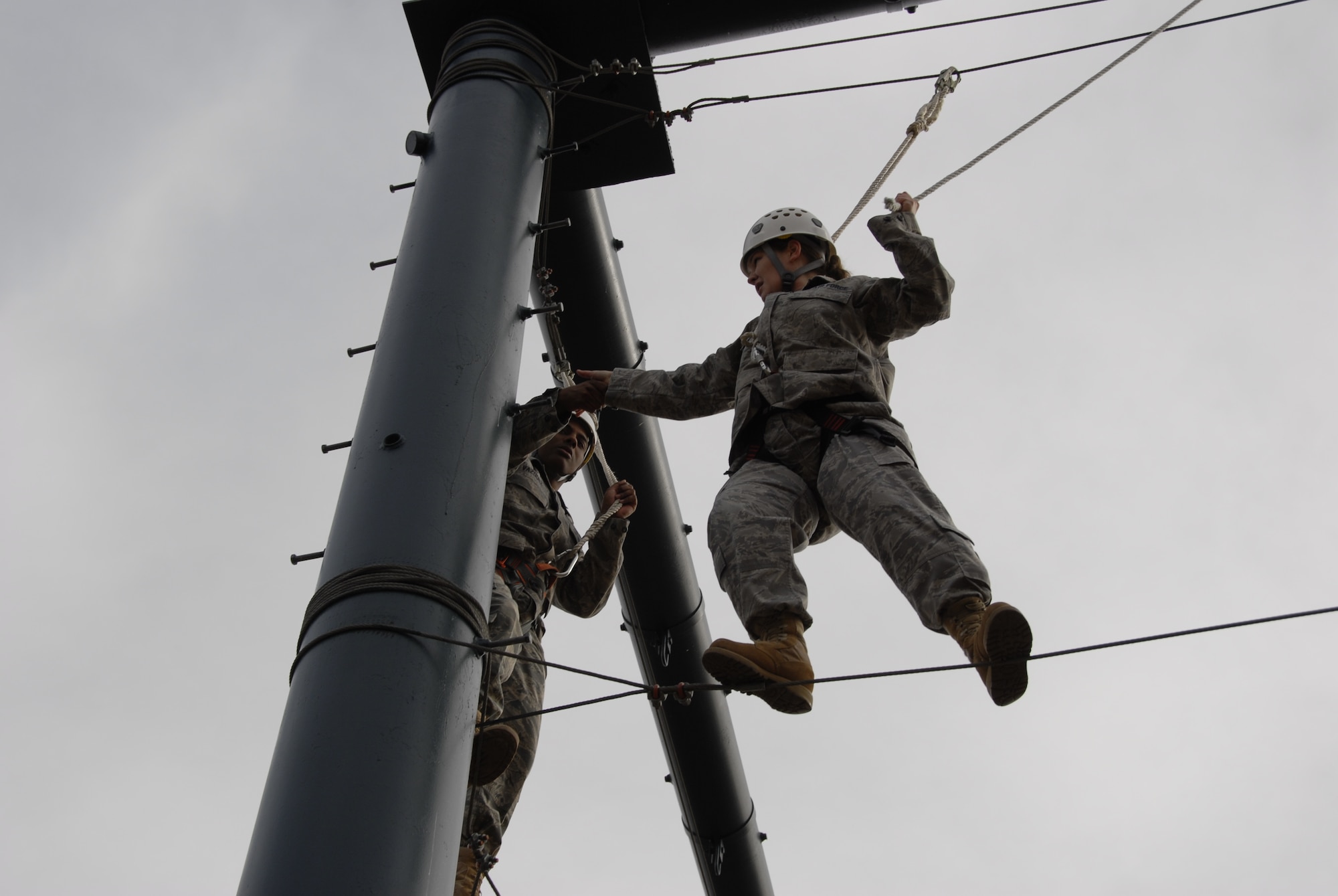 HANSCOM AIR FORCE BASE, Mass. - Senior Airman Aisling Loftus (right), 551st Electronic Systems Wing knowledge operations management, completes, with the help of Senior Airman Daniel Vazquez, 66th Security Forces Squadron, one of four sections to the approximately 20-foot high Big Blue Monster, an exercise designed to build teamwork, communication and confidence on the U.S. Air Force Academy's Adventure Based Learning Course in Colorado Springs, Colo. 28 Hanscom Airmen traveled to the Academy Nov. 5 through 8 to develop camaraderie, observe cadet training, and experience Air Force Academy athletic events. (U.S. Air Force Photo by Capt. Geoff Buteau)