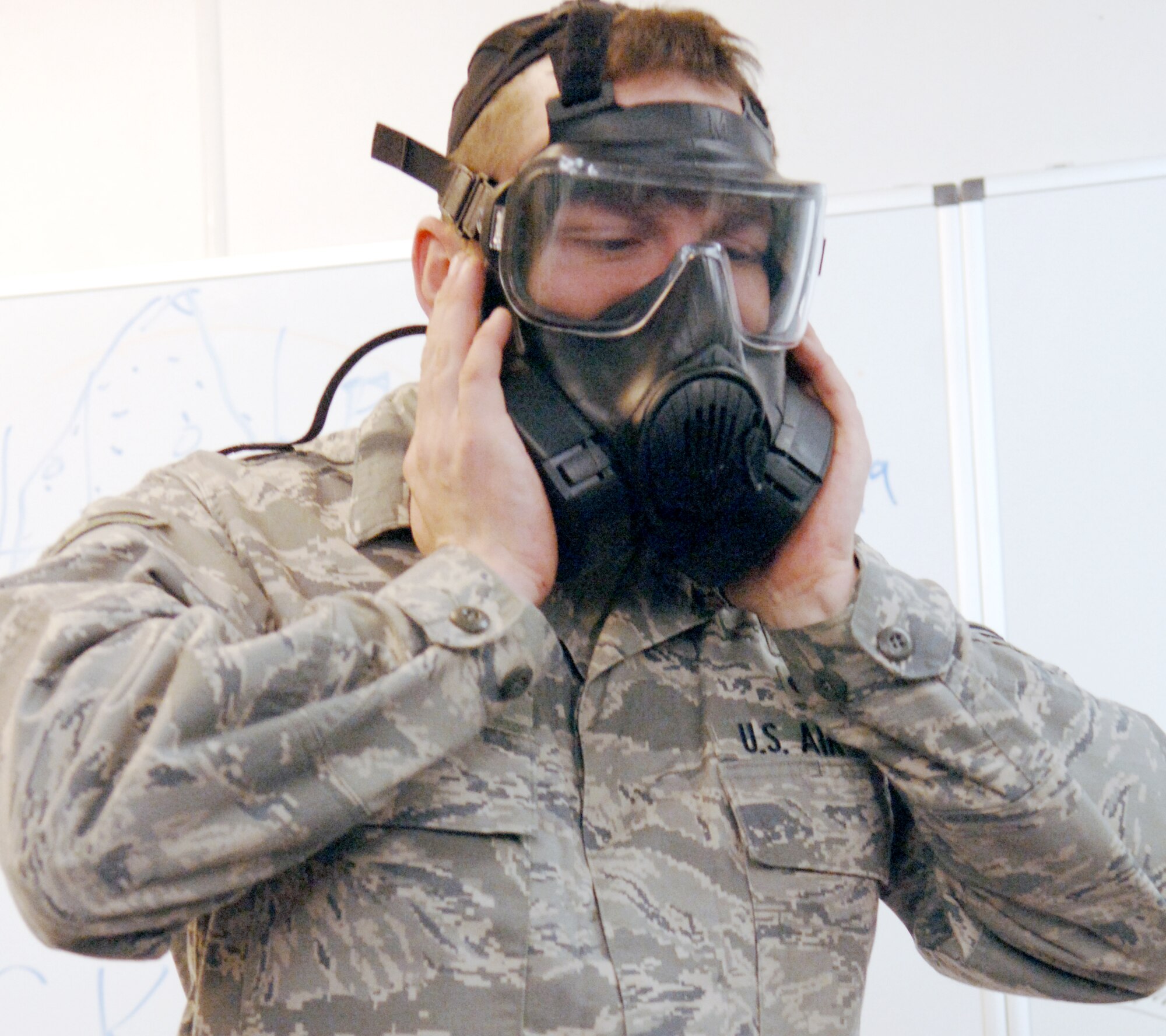 Airman 1st Class Michael Balbaugh demonstrates how to check the seal of the M-50 Joint Service General Purpose Mask, Nov. 5, 2009, Ramstein Air Base, Germany. The mask has two filters as opposed to the one canister filter on the MCU-2 mask. Airman Balbaugh is from the 886th Civil Engineer Squadron as a readiness and emergency management apprentice. (U.S. Air Force photo/Senior Airman Amanda Dick)