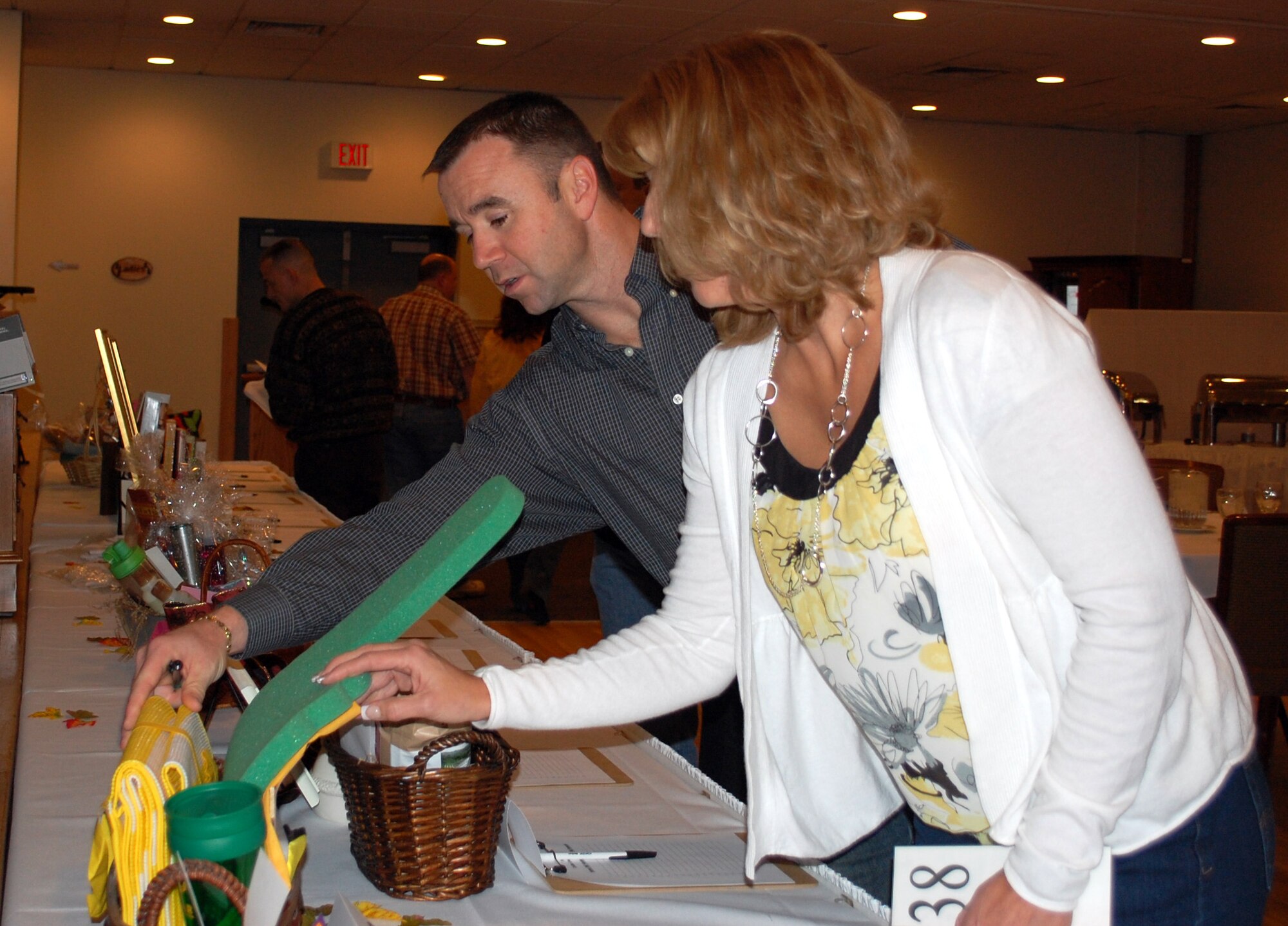 Senior Master Sgt. Scott Knupp and his wife, Karen, look over a silent auction gift basket entitled "Go Rustlers," which was described as "just the basket for those enthusiastic and loyal CMR fans who want to show their team spirit." Sergeant Knupp is a member of the 341st Civil Engineer Squadron. (U.S. Air Force photo/Valerie Mullett)