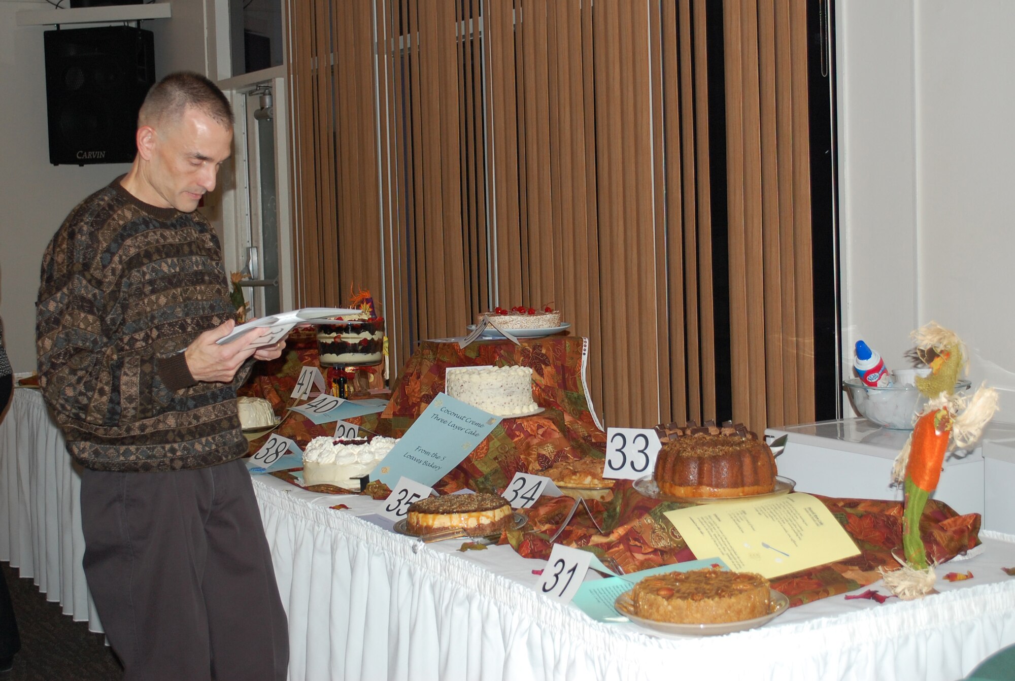 Col. John Patricola, 341st Mission Support Group commander, reads the description of some of the desserts donated by Malmstrom spouses that would be auctioned off at the Mercantile Auction Nov. 7. (U.S. Air Force photo/Valerie Mullett)