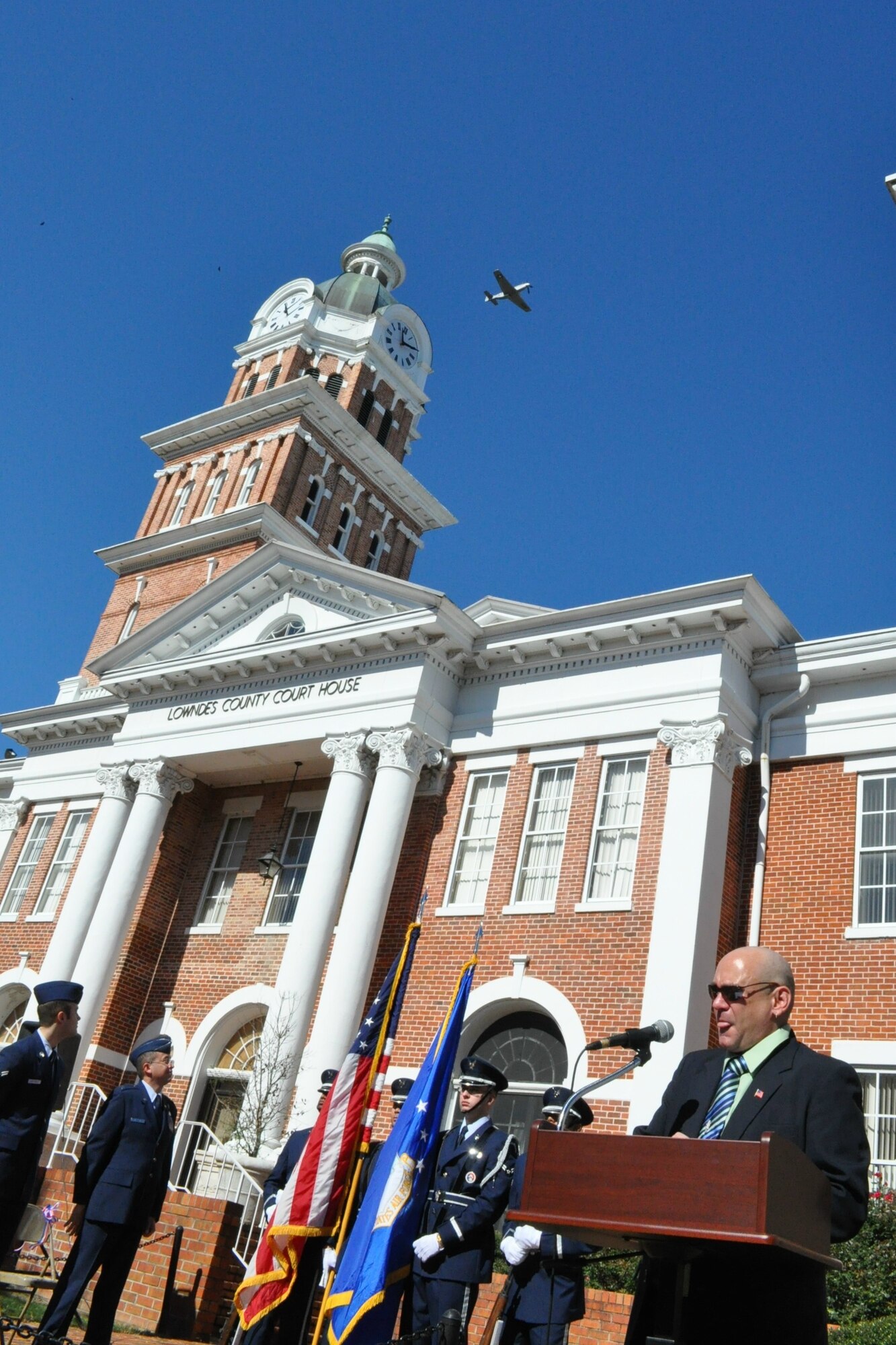 A P-51 Mustang flies over the Veteran’s Day Ceremony signaling the end of the moment of silence at 11 minutes after the eleventh hour Nov. 7. (U.S. Air Force photo/Sonic Johnson)