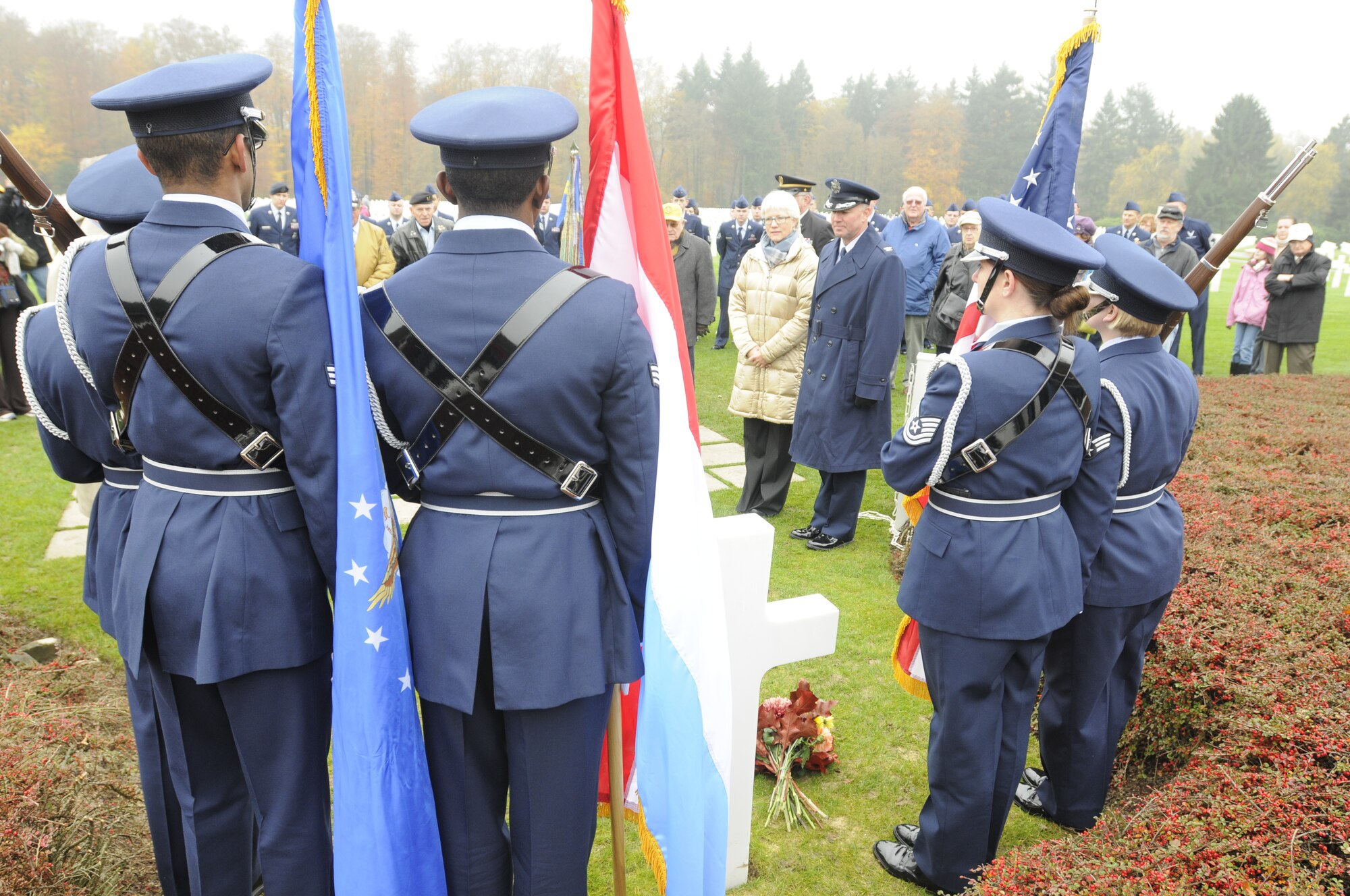 SPANGDAHLEM AIR BASE, Germany -- The 702nd Munitions Support Squadron Color Guard from Buechel Air Base, Germany, stands at attention by the grave of Gen. George Smith Patton, Third Army commander during World War II, as Helen Patton-Plusczyk, General Patton's granddaughter, and Col. Tip Wight, 52nd Fighter Wing commander, pay their respect to the soldiers who died fighting in World War II during the annual Veterans Day ceremony at the Luxembourg American Cemetery and Memorial in Luxembourg City Nov. 11. The 50.5 acre cemetery is one of 14 American cemeteries established overseas after WWII and contains the remains of more than 5,000 American servicemembers who died fighting the second world war. (U.S. Air Force photo/Maj. Jillian Torango)