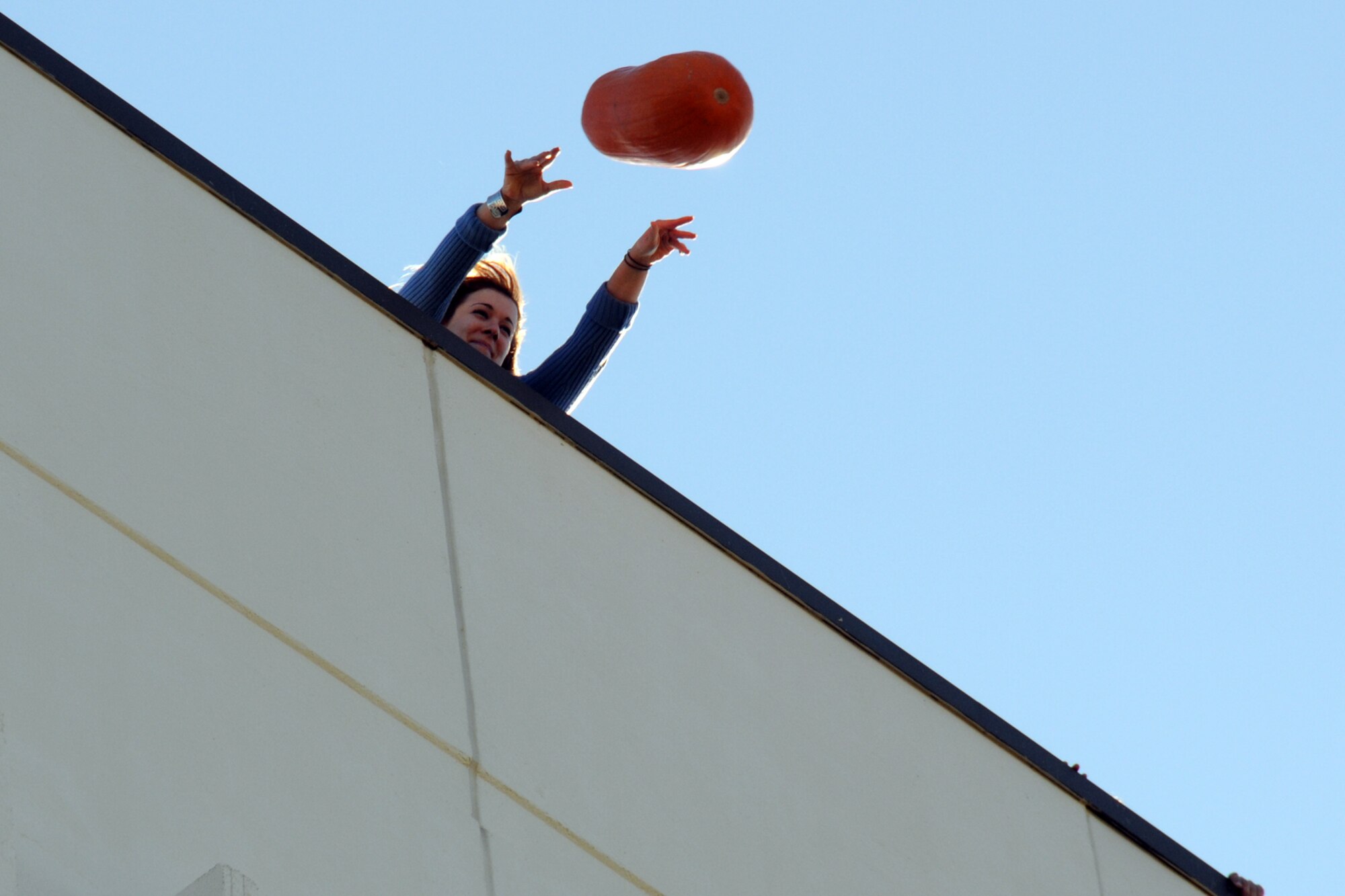 EGLIN AIR FORCE BASE, Fla. – Jasmine DeNamur, 96th Air Base Wing Public Affairs, tosses a pumpkin from the top of a six-story building during a Pumpkin Smash competition Nov. 12. The event was hosted by the 53rd Wing as a fundraiser for their upcoming Children’s Christmas Party. (U.S. Air Force/ Airman 1st Class Anthony Jennings)