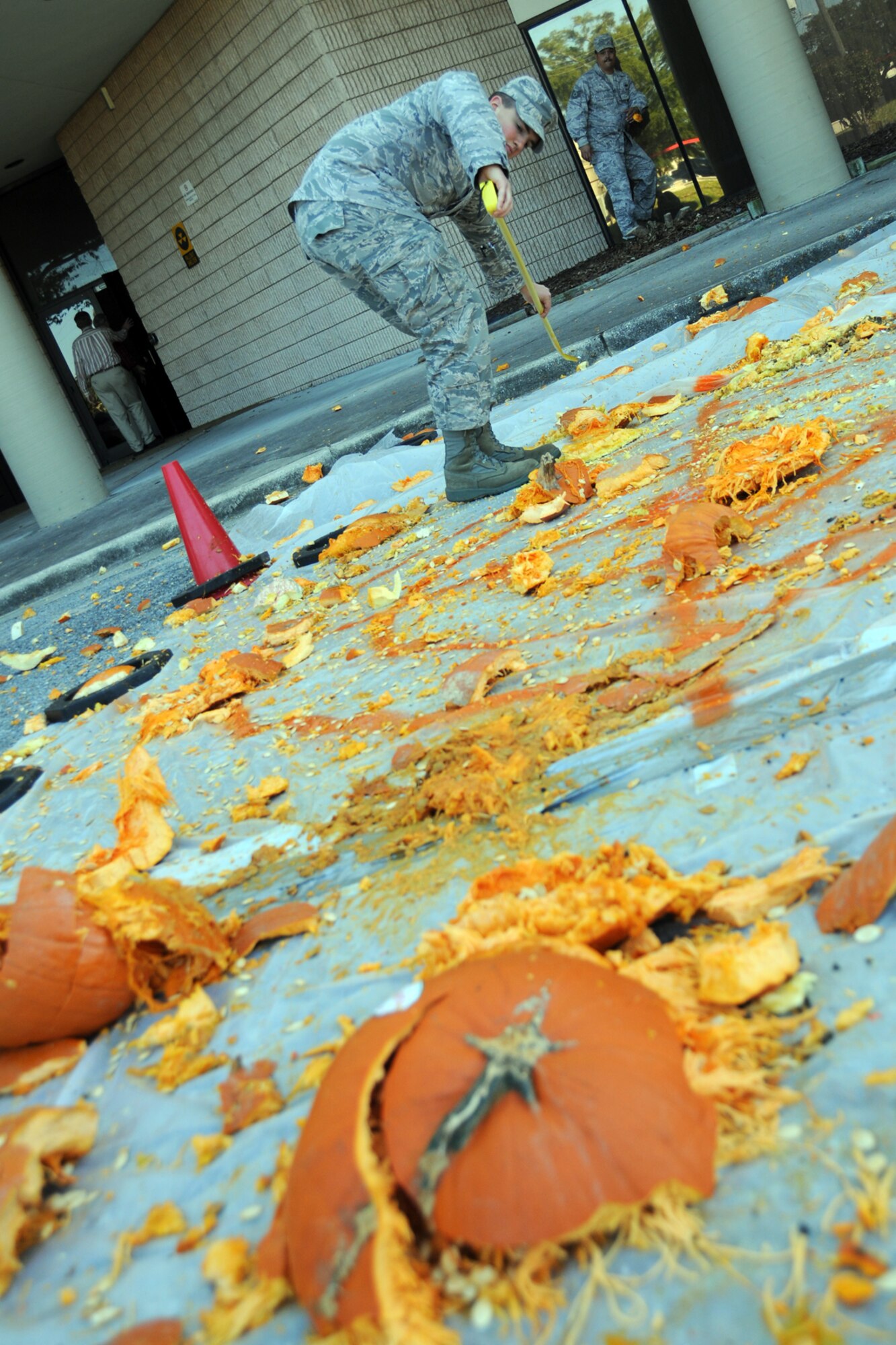 EGLIN AIR FORCE BASE, Fla. – 2nd Lt. Matthew Saar, 28th Test and Evaluation Squadron, measures the impact location of obliterated pumpkin remains from the target during a Pumpkin Smash competition Nov. 12. Participants tossed pumpkins from the top of a six-story building, aiming at a target on the ground. The event was hosted by the 53rd Wing as a fundraiser for their upcoming Children’s Christmas Party. (U.S. Air Force/ Airman 1st Class Anthony Jennings)