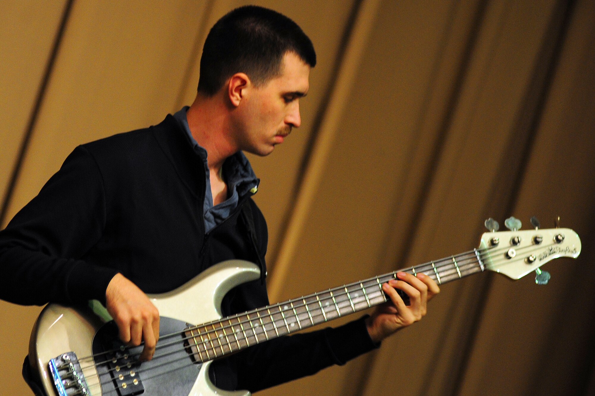 BISHKEK, Kyrgyzstan -- Senior Airman Andrew Peck, U.S. Air Forces Central Sirocco Band bass guitarist, carries the rhythm during a performance at the Kyrgyz-Russian Slavic University, Nov. 13, 2009. The Sirocco Band plays a wide variety of rock, oldies and pop music. They are stationed at a base in Southwest Asia and are deployed from Lackland air Force Base, Texas. (U.S. Air Force photo/Senior Airman Steele C. G. Britton)