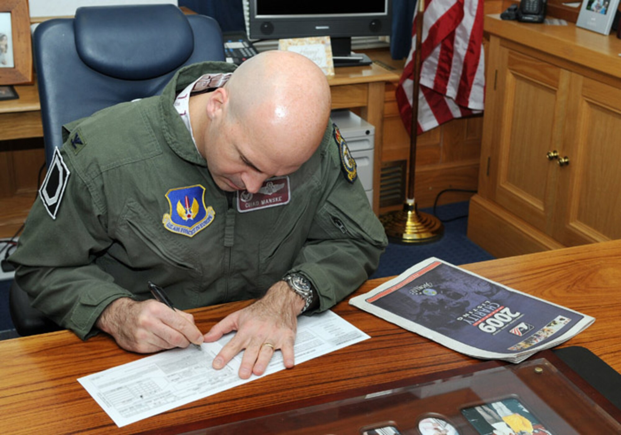 RAF MILDENHALL, England -- Col. Chad Manske, 100th Air Refueling Wing commander, completes his 2009 Combined Federal Campaign-Overseas pledge card here Nov. 13. Personal life experiences influenced the colonel to direct his contribution to the American Cancer Society, where it may be applied to future research. Three of Colonel Manske's grandparents were diagnosed and later passed away from the effects of various cancers. The CFC-O runs through Dec. 6 for federal employees to contribute during the campaign. Donations are accepted yearlong at www.cfcoverseas.org. (U.S. Air Force photo/Senior Airman Thomas Trower)