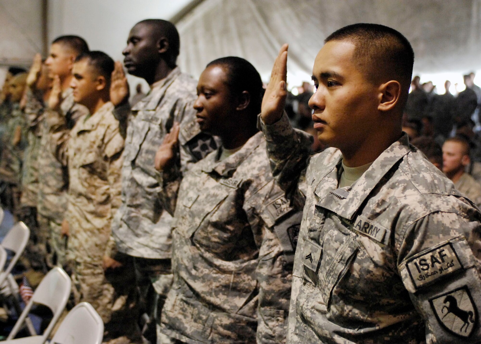 BAGRAM AIRFIELD, Afghanistan -- Army Cpl. Cylee Yagao, a Security Forces team leader for the Khost Provincial Reconstruction Team, along with fellow military members take the Oath of Allegiance Nov. 12, 2009.  A Naturalization Ceremony was held at the morale, welfare and recreation clamshell here making more than 130 service men and women U.S. citizens.  Corporal Yagao, a Philippine native, found out that he was part of the Bagram naturalization ceremony through emails and phone calls from his Las Vegas home station, 1-221st Calvary Regiment.  (U.S. Air Force photo/Senior Airman Felicia Juenke)