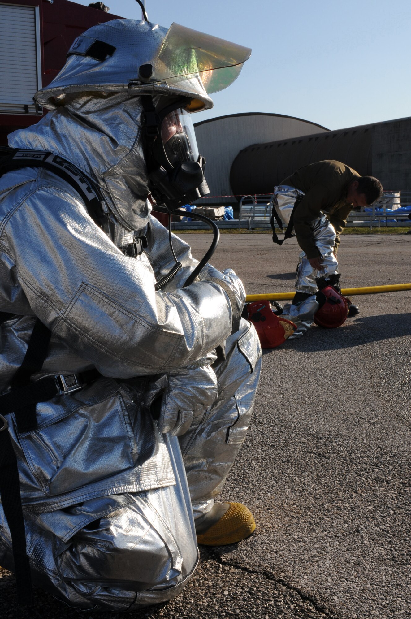 A firefighter assigned to the 31st Civil Engineer Squadron waits for an Italian Air Force firefighter from Decimomannu Air Base, Sardinia, Italy, to suit up during a live fire exercise, Nov. 11, 2009.  Four firefighters from Decimomannu AB took part in the three-day training course at Aviano Air Base, Italy.  The training consisted of hydrazine, F-16 aircraft emergency response procedures and pilot egress, structural fire fighting tactics and strategy.
(U.S. Air Force photo/ Senior Airman Nadine Y. Barclay)
