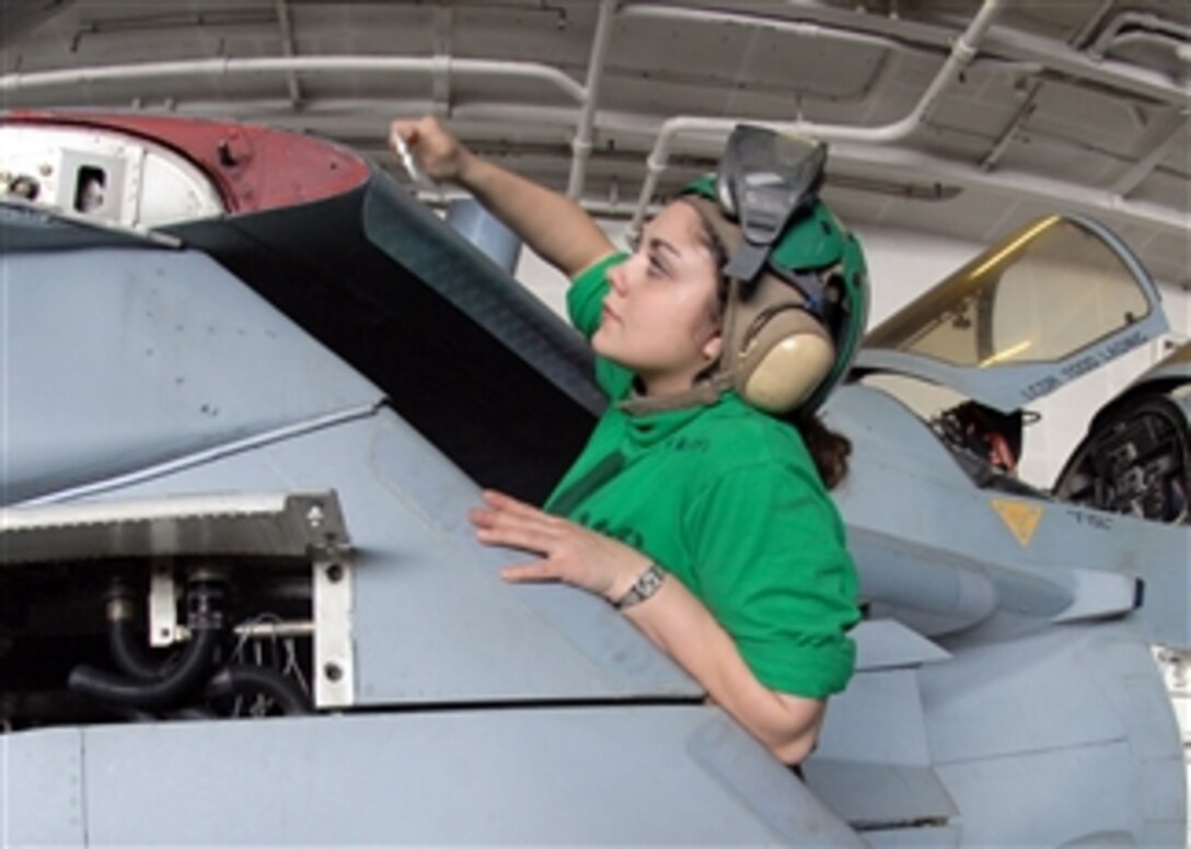 U.S. Navy Airman Mary Jackson, assigned to Electronic Attack Squadron 136, applies leading edge tape to the wings of an E/A-6B Prowler aircraft in the hangar bay of the aircraft carrier USS George Washington (CVN 73) underway in the Pacific Ocean on Nov. 6, 2009.  The ship, the Navy's only permanently forward-deployed aircraft carrier, is supporting security and stability in the western Pacific Ocean.  