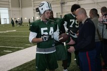 FLORHAM PARK, N.J. -- Marines from Recruiting Station New Jersey meet with Kenwin Cummings, linebacker, New York Jets, during a tour of the team's practice facility Nov. 13. The team invited service members to their practice and Sunday the Jets will honor military veterans during their military appreciation day. (Official Marine Corps photo by Sgt. Randall A. Clinton)