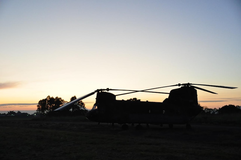 ILOPANGO, El Salvador – A CH-47 Chinook assigned to Joint Task Force-Bravo sits and waits for the sun to rise over the horizon Nov. 14. JTF-Bravo has been providing vital relief supplies in order to help stabilize the region after a devastating flood Nov. 8. In three days the team of four helicopters and crew has distributed more than 172,700 pounds of supplies in a total of 42 flight hours (U.S. Air Force photo/Staff Sgt. Chad Thompson).