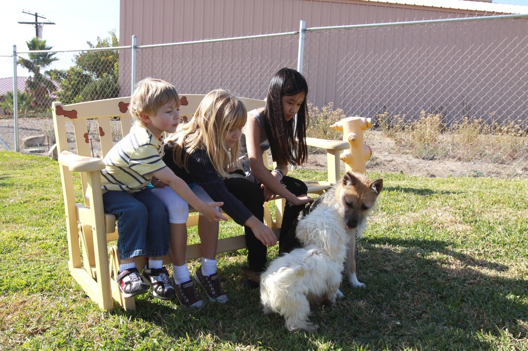 (Left to right) Colin, Meigan and Alexandria Grabman, play with two dogs in the new dog play area at Camp Pendleton’s Animal Shelter, Nov. 14. The new 1,500 sq. feet area is enclosed by a snake fence, has a dog house, a real fire hydrant and a seating bench.