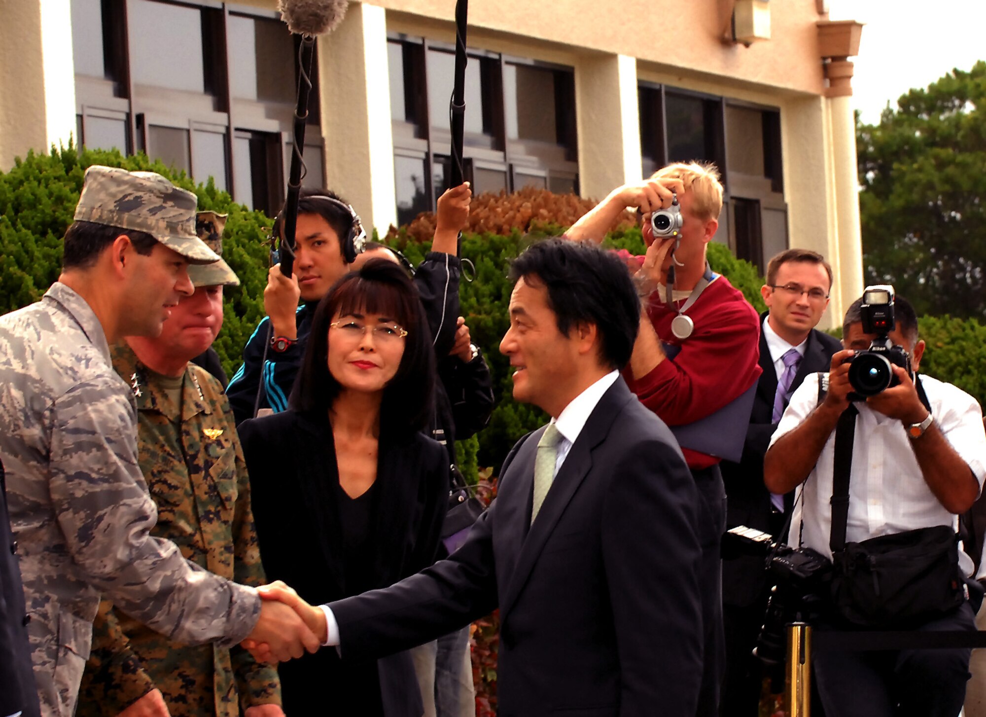 Brig. Gen. Ken Wilsbach, 18th Wing commander, and Lt. Gen. Terry Robling, III Marine Expeditionary Force commanding general, greet Japanese Foreign Minister Katsuya Okada during a site visit to Kadena Monday. According to Japanese press reports, the foreign minister toured Kadena to personally research the possibility of combining Marine Corps Air Station Futenma with the air base. The relocation of Futenma is a key measure of a major realignment plan signed by both countries three years ago. Nearly 50,000 U.S. troops are currently stationed in Japan.(Air Force/Staff Sgt. Jason Lake)