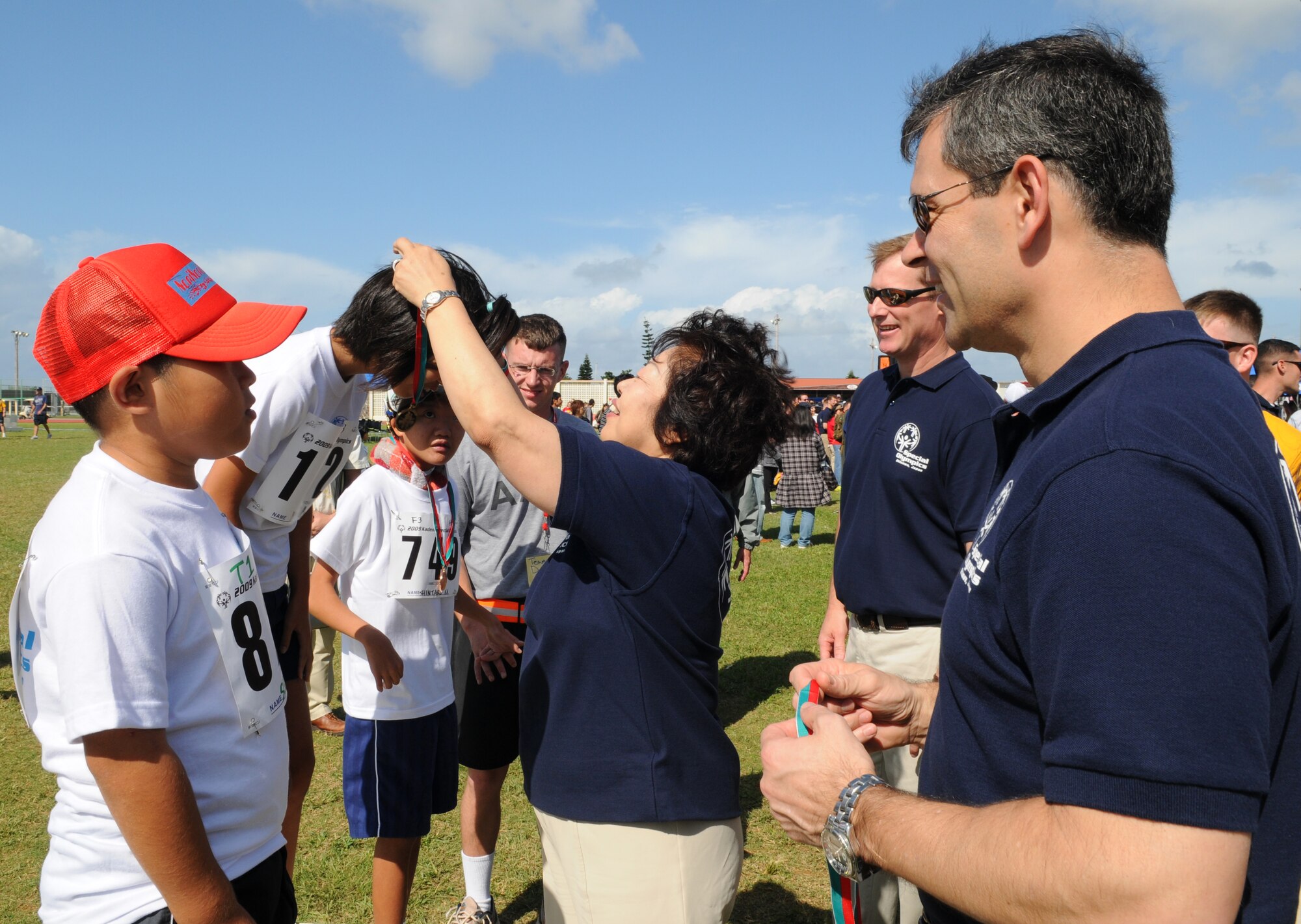 Gen. Ken Wilsbach, 18th Wing commander, presents a medal to an Okinawan athlete after competing in the 30 meter dash during the Kadena Special Olympics Nov. 14, 2009, Kadena Air Base, Japan. Kadena hosted the 10th Annual Special Olympic Games and Art Festival for special needs Okinawan and American adult and child athletes.  (U.S. Air Force photo/Airman 1st Class Amanda Grabiec) 